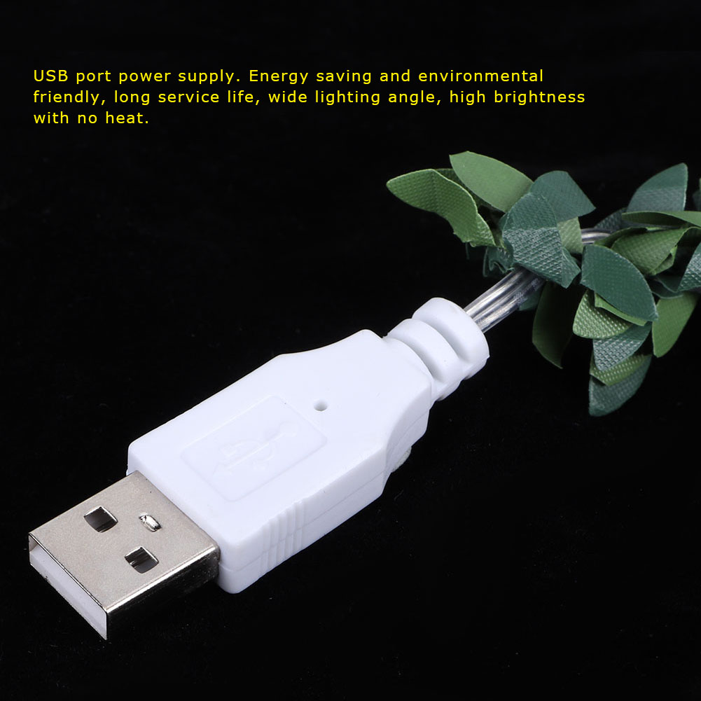 Weißer USB-Anschluss mit silbernen Zinken, grüne Blattdekoration rechts. Schwarzer Hintergrund.
