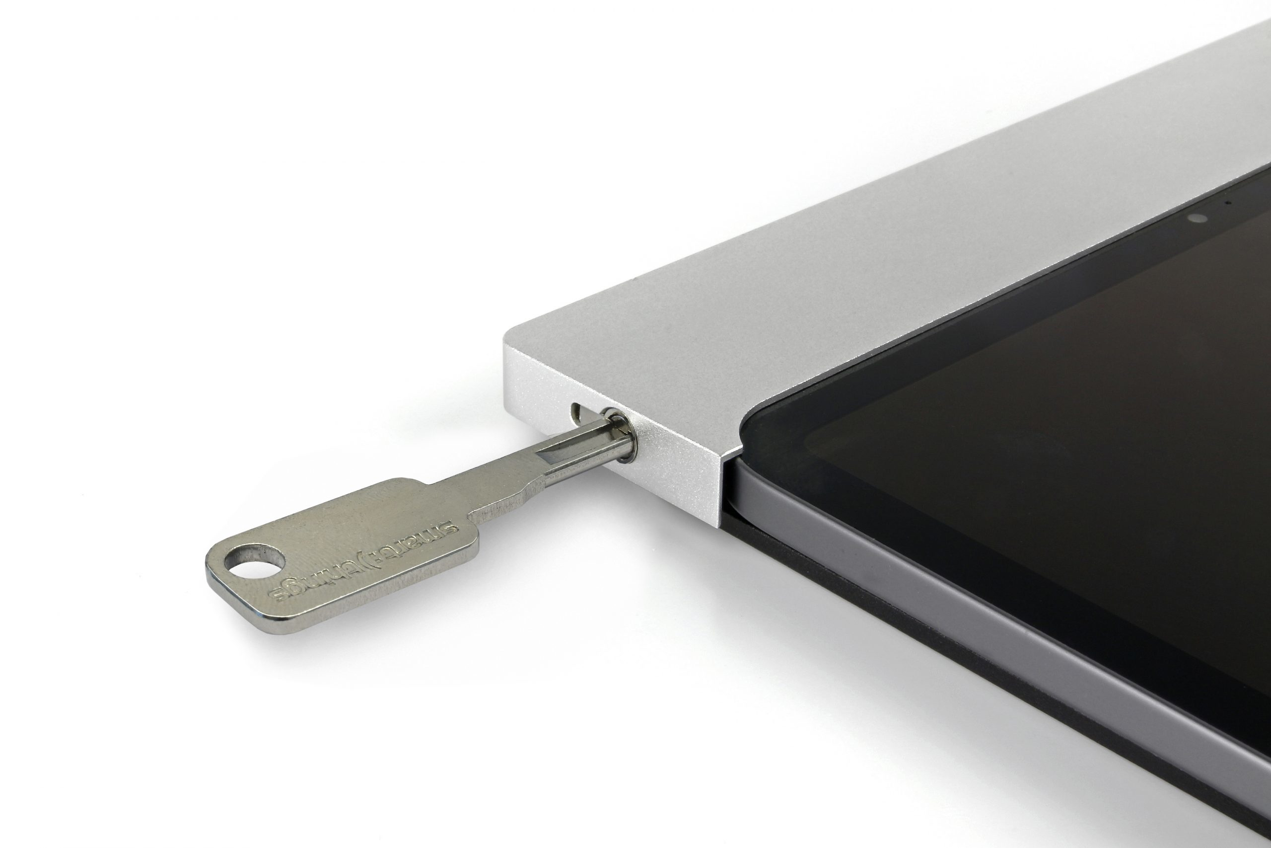 Une clé argentée insérée dans une tablette grise. L'écran de la tablette est noir. Le fond est blanc.