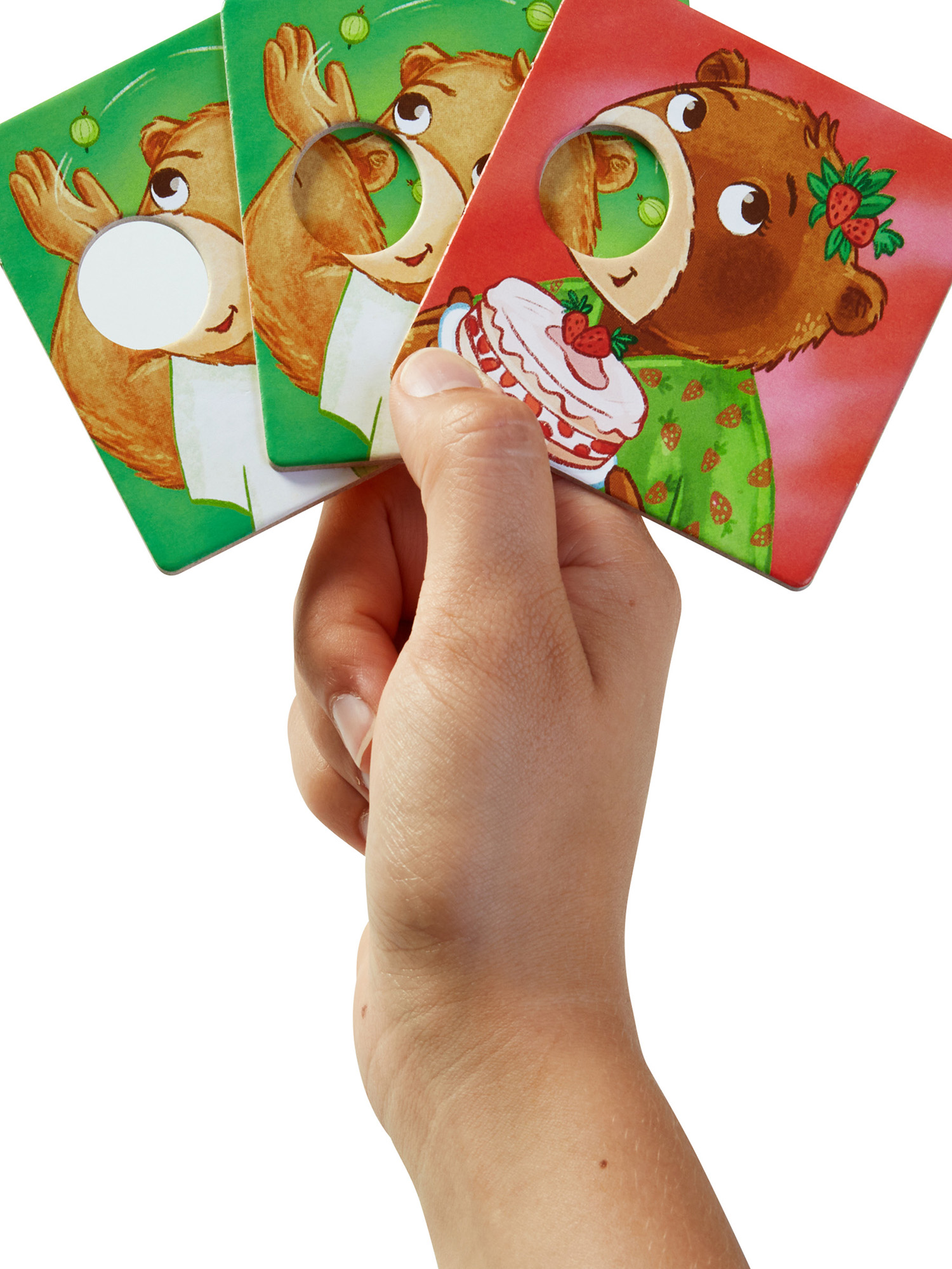 Mano che tiene in mano carte con orsi dei cartoni animati. Un orso indossa un fermacapelli a forma di fragola e tiene una torta. Altri orsi sono su carte verdi.