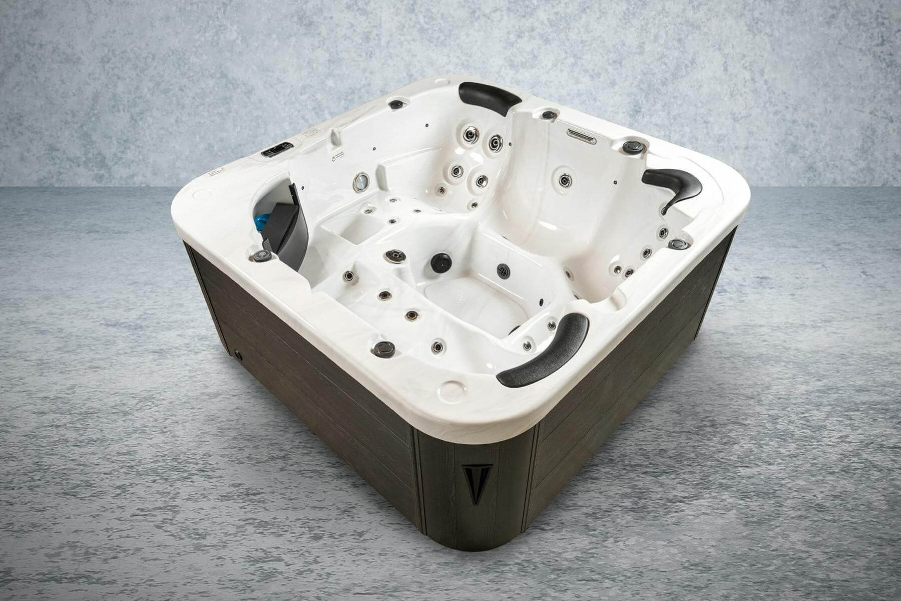 Ein weißer und brauner Whirlpool mit mehreren Düsen, Sitzen und einem dunkelbraunen Äußeren, vor einem strukturierten grauen Hintergrund.