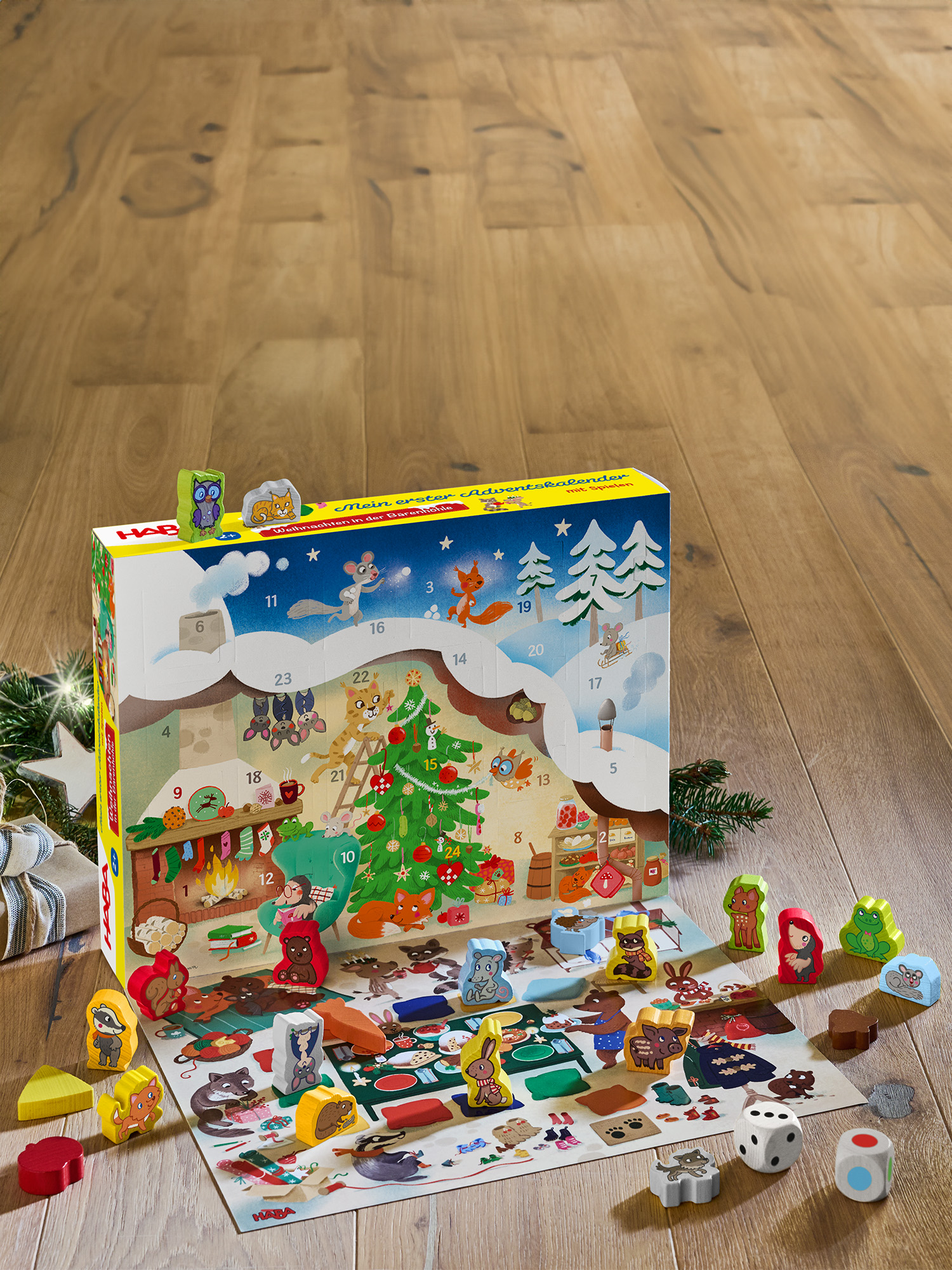 Ein Adventskalender mit Holztierefiguren. Ein Weihnachtsbaum, Kamin und Würfel stehen auf dem Tisch. Der Hintergrund ist Holz.