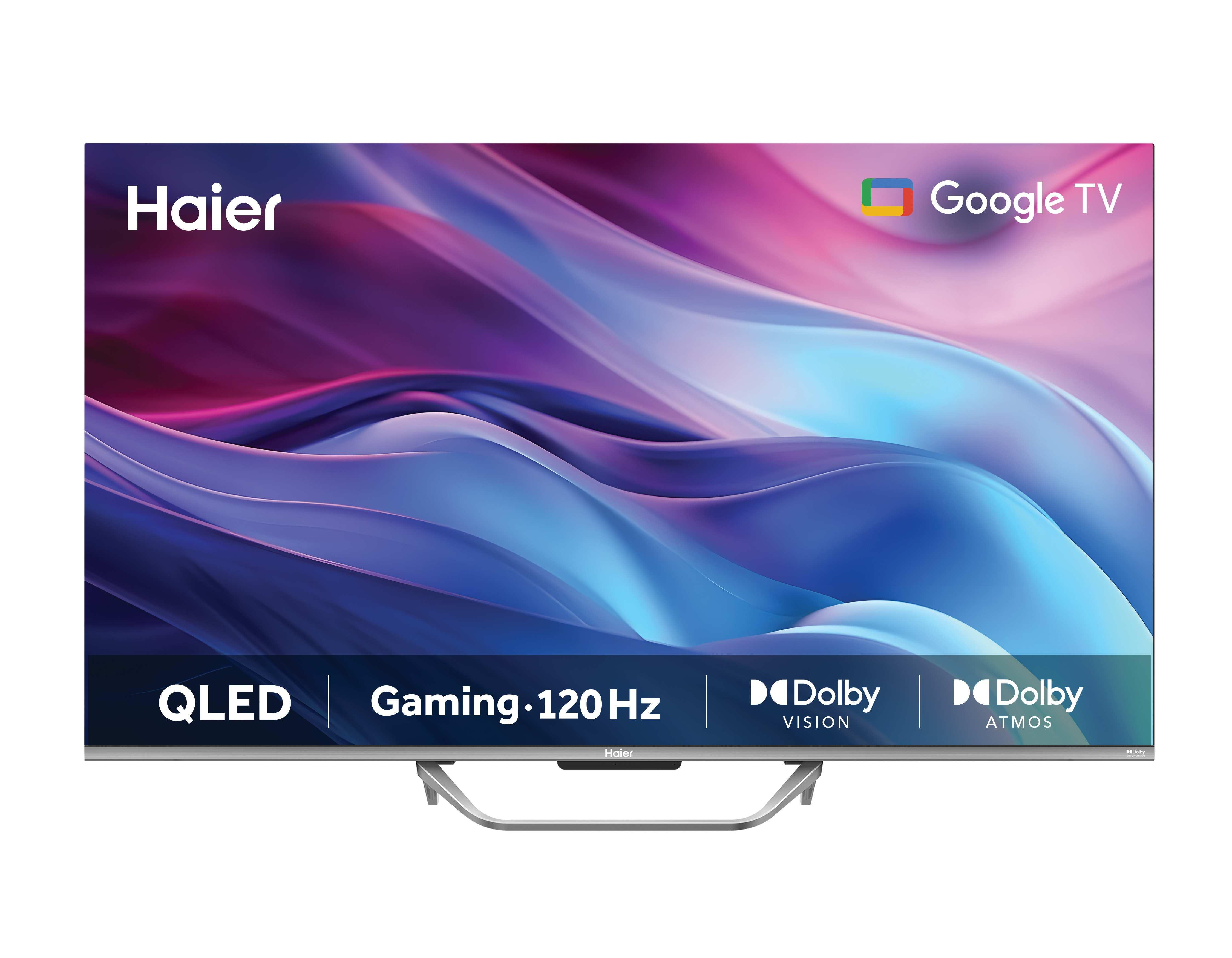 Un téléviseur Haier QLED avec Google TV. Les fonctionnalités incluent Gaming 120Hz, Dolby Vision et Atmos. L'écran affiche un design abstrait bleu et violet.