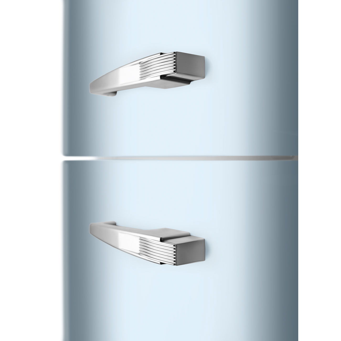 Primer plano de un refrigerador azul claro. Tiene dos manijas de acero inoxidable. La manija superior está encima de la inferior.