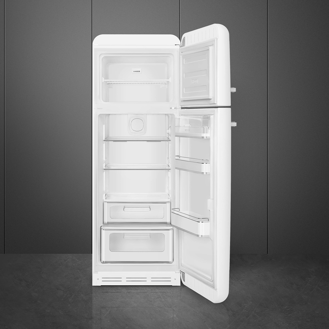 Un refrigerador blanco con la puerta abierta, revelando estantes y cajones. El fondo es una pared gris oscuro y un suelo gris.