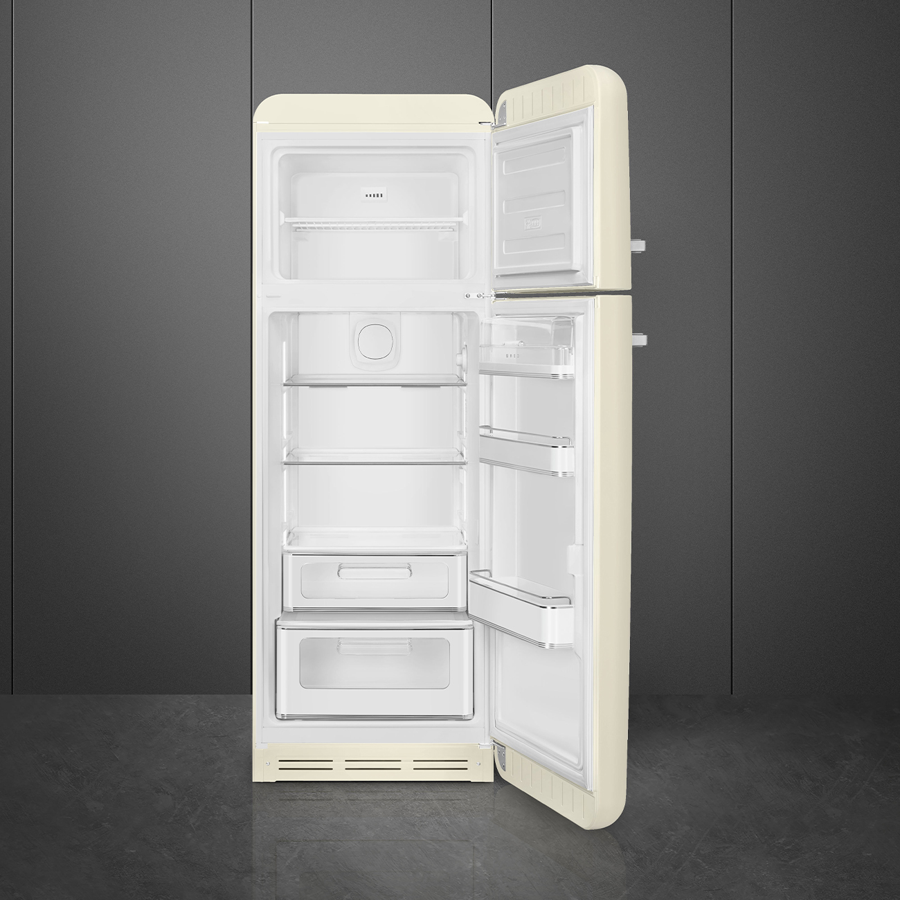 Refrigerador retro crema con puerta abierta. Se ven estantes, cajones y congelador interiores. Pared y suelo grises oscuros en el fondo.