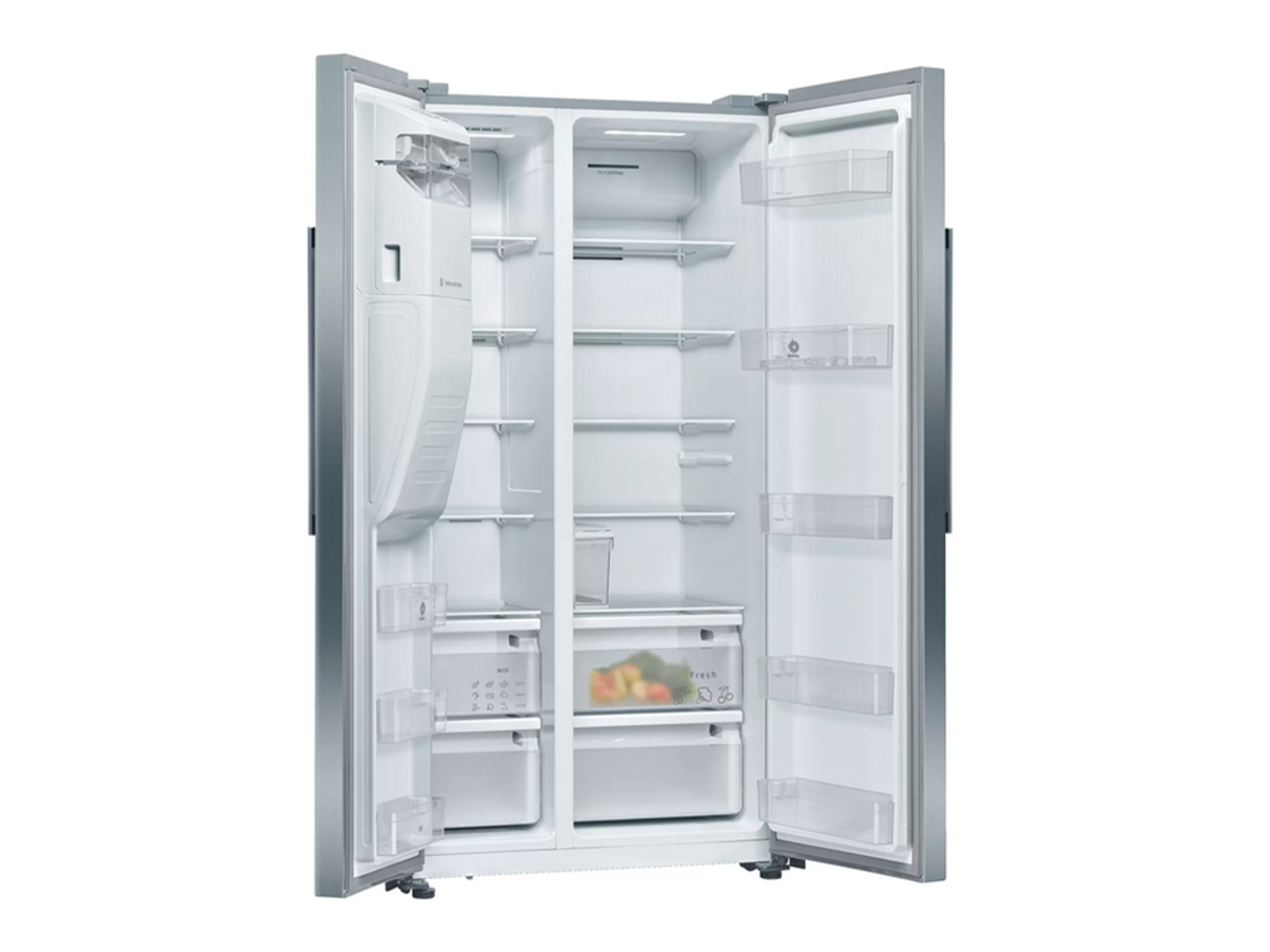 Un refrigerador de lado a lado de acero inoxidable abierto y vacío. El interior tiene estantes, cajones y compartimentos. Se ven verduras en el cajón inferior.