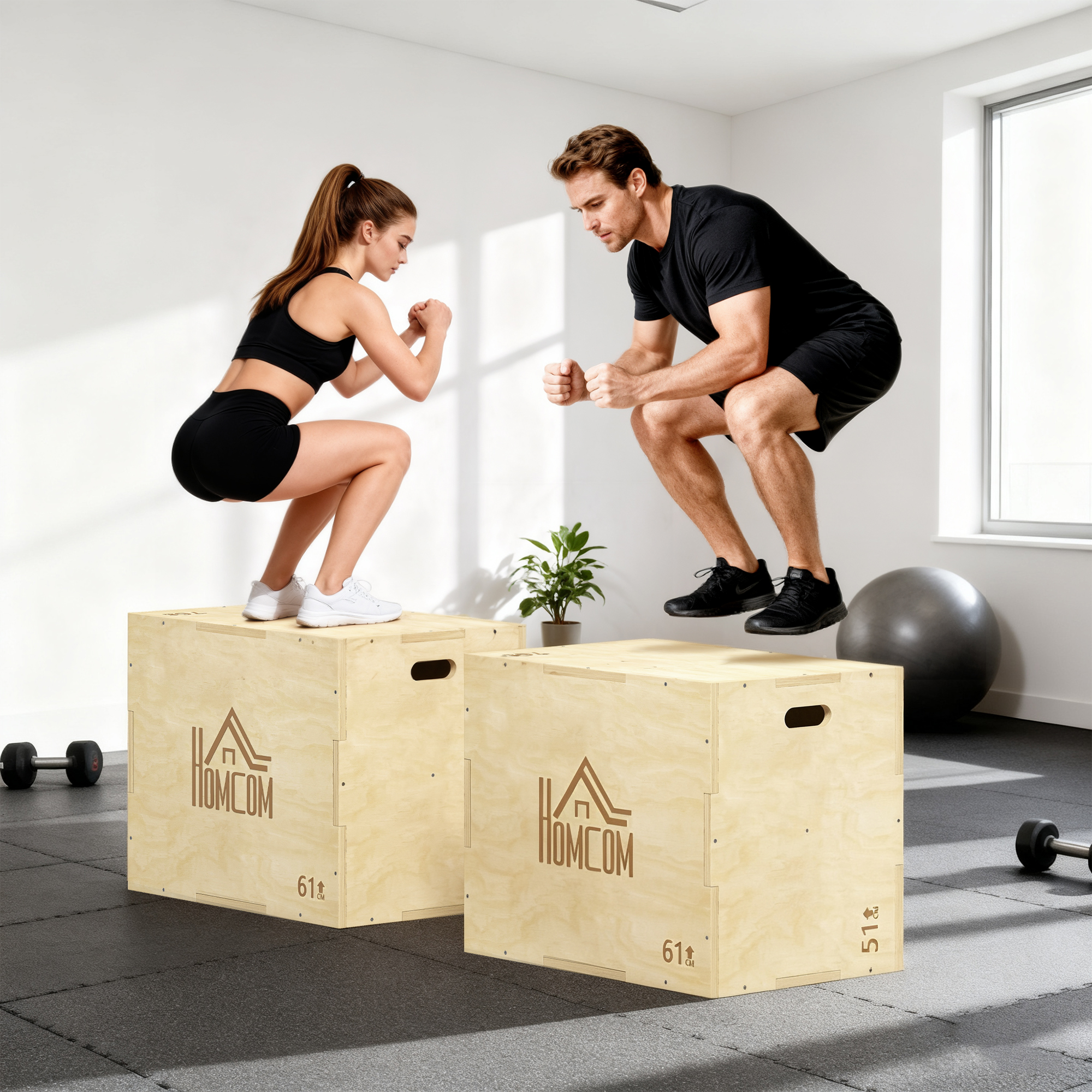 Un hombre y una mujer saltan sobre cajas de madera en un gimnasio. La mujer viste ropa deportiva negra. El hombre también.