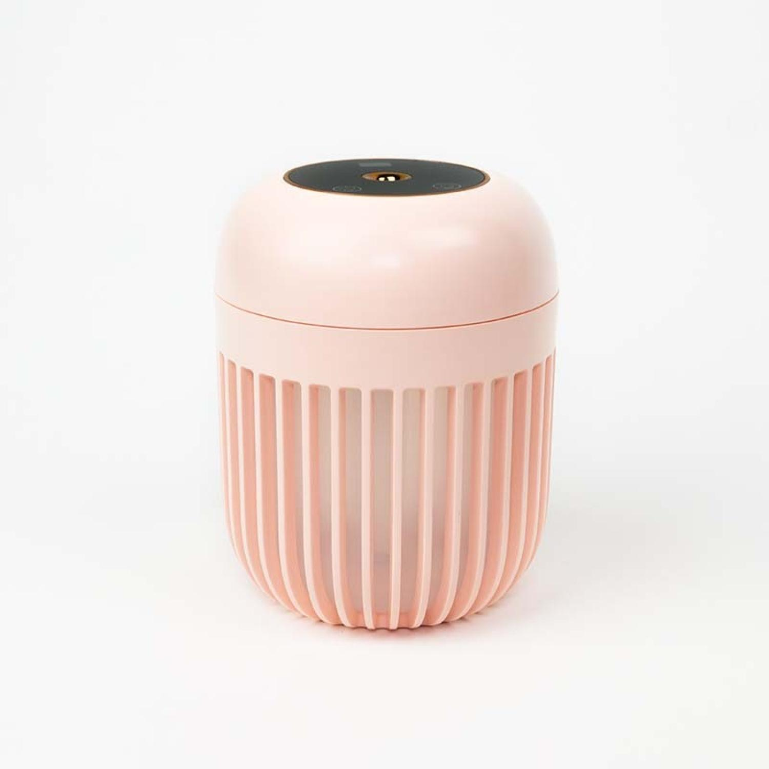 Un humidificador rosa sobre fondo blanco. La parte superior es negra con botones. La parte inferior tiene crestas verticales.