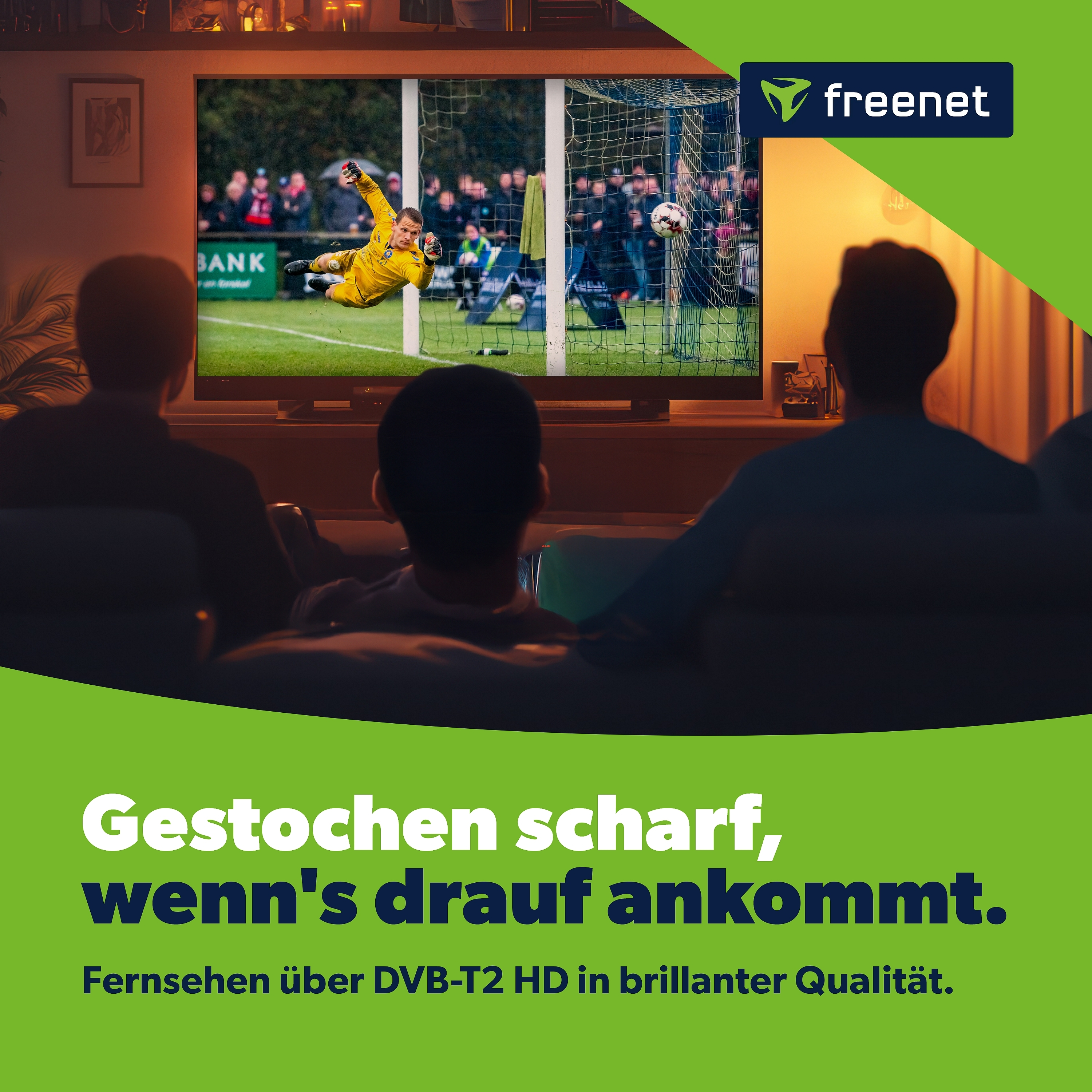 Menschen schauen ein Fußballspiel im Fernsehen. Der Torwart taucht nach dem Ball. Oben rechts ist ein freenet-Logo.