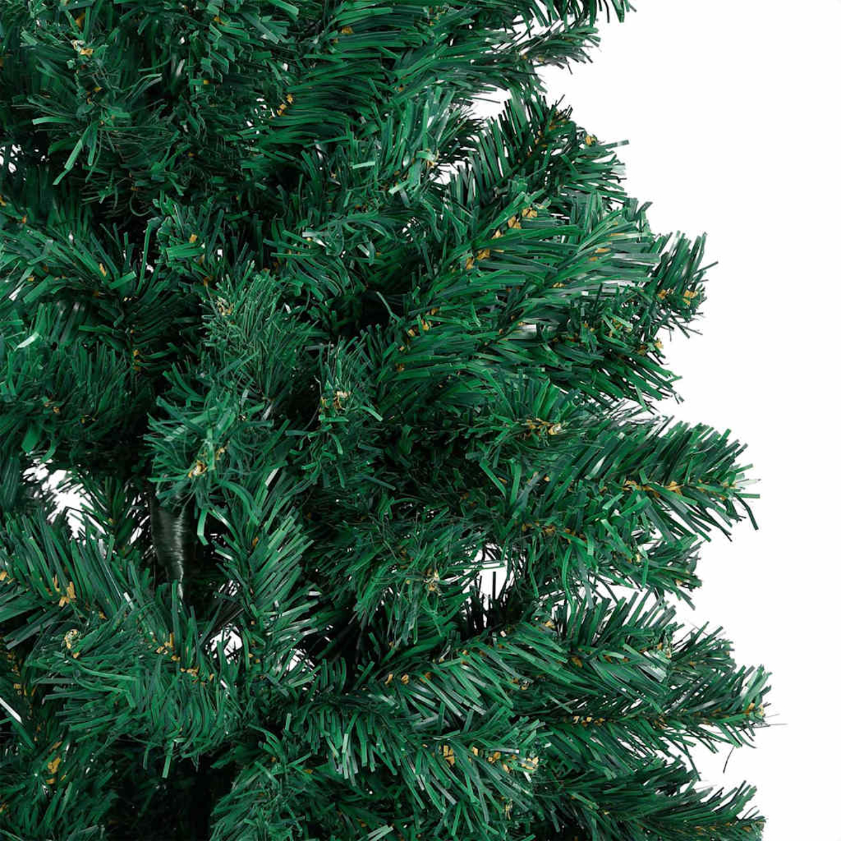 Nahaufnahme eines grünen künstlichen Weihnachtsbaums. Die Zweige sind dicht und voll, mit einer Mischung aus dunklen und hellen grünen Nadeln.
