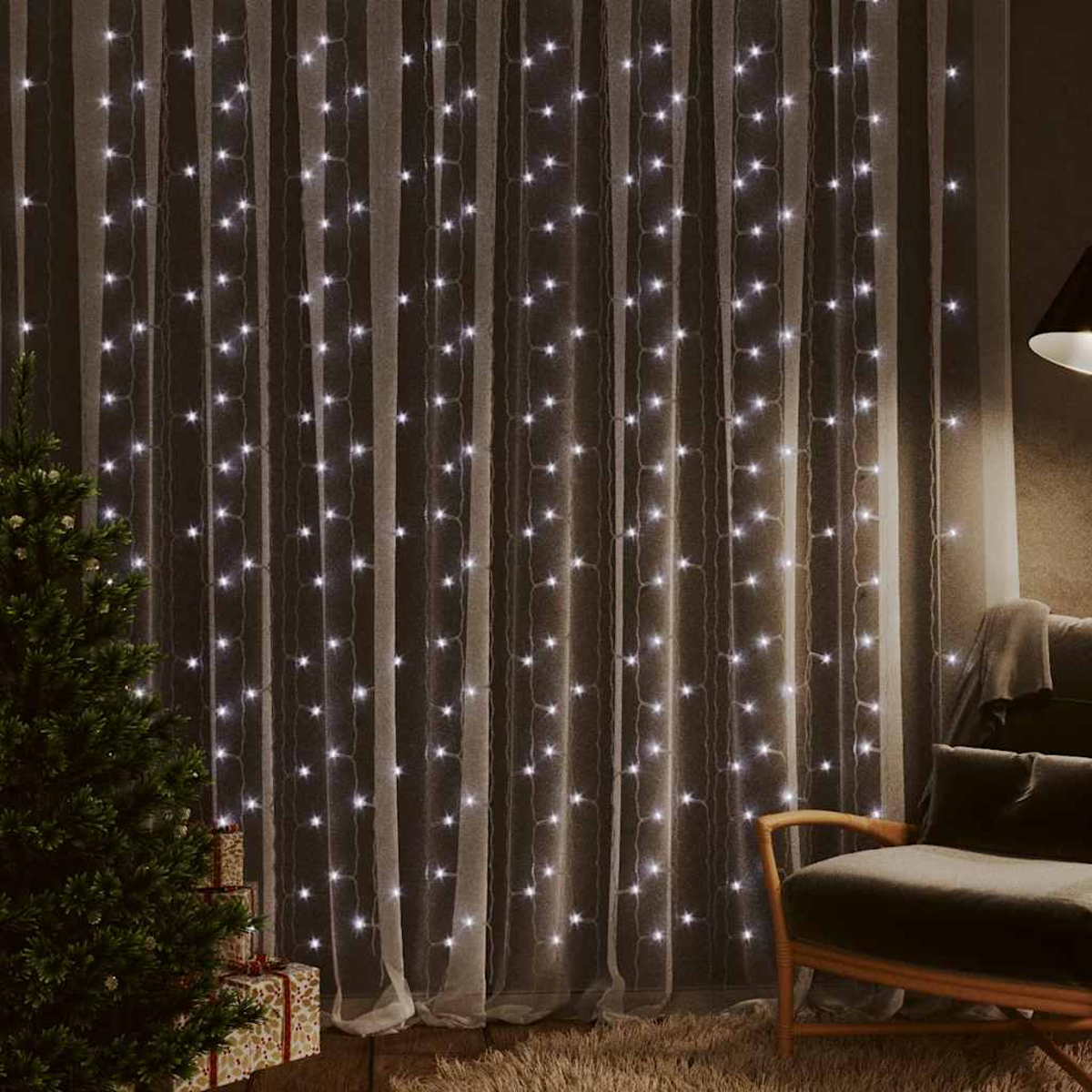 Ein beleuchteter Vorhang aus weißen Lichterketten. Links ein Weihnachtsbaum, rechts ein Stuhl und eine Lampe.