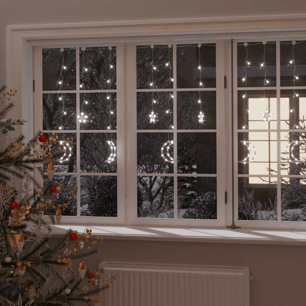 Ein Fenster mit Weihnachtsbeleuchtung, ein Baum mit Ornamenten und eine verschneite Szene im Freien bei Nacht. Mond- und sternförmige Lichter.