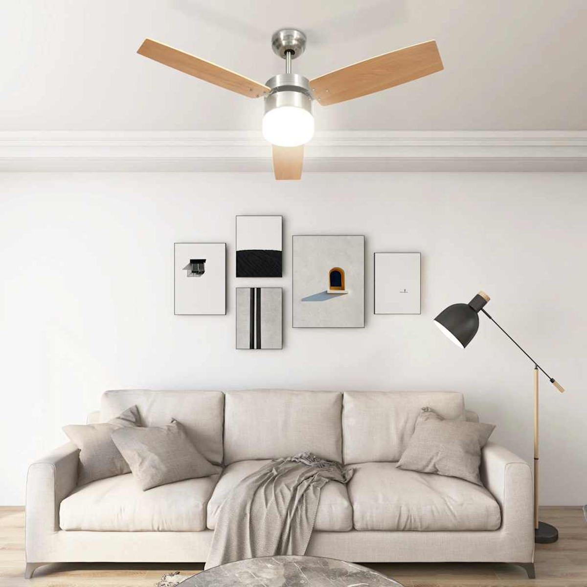 Un salón con ventilador de techo, sofá, obras de arte y lámpara de pie. Los tonos neutros dominan la escena.