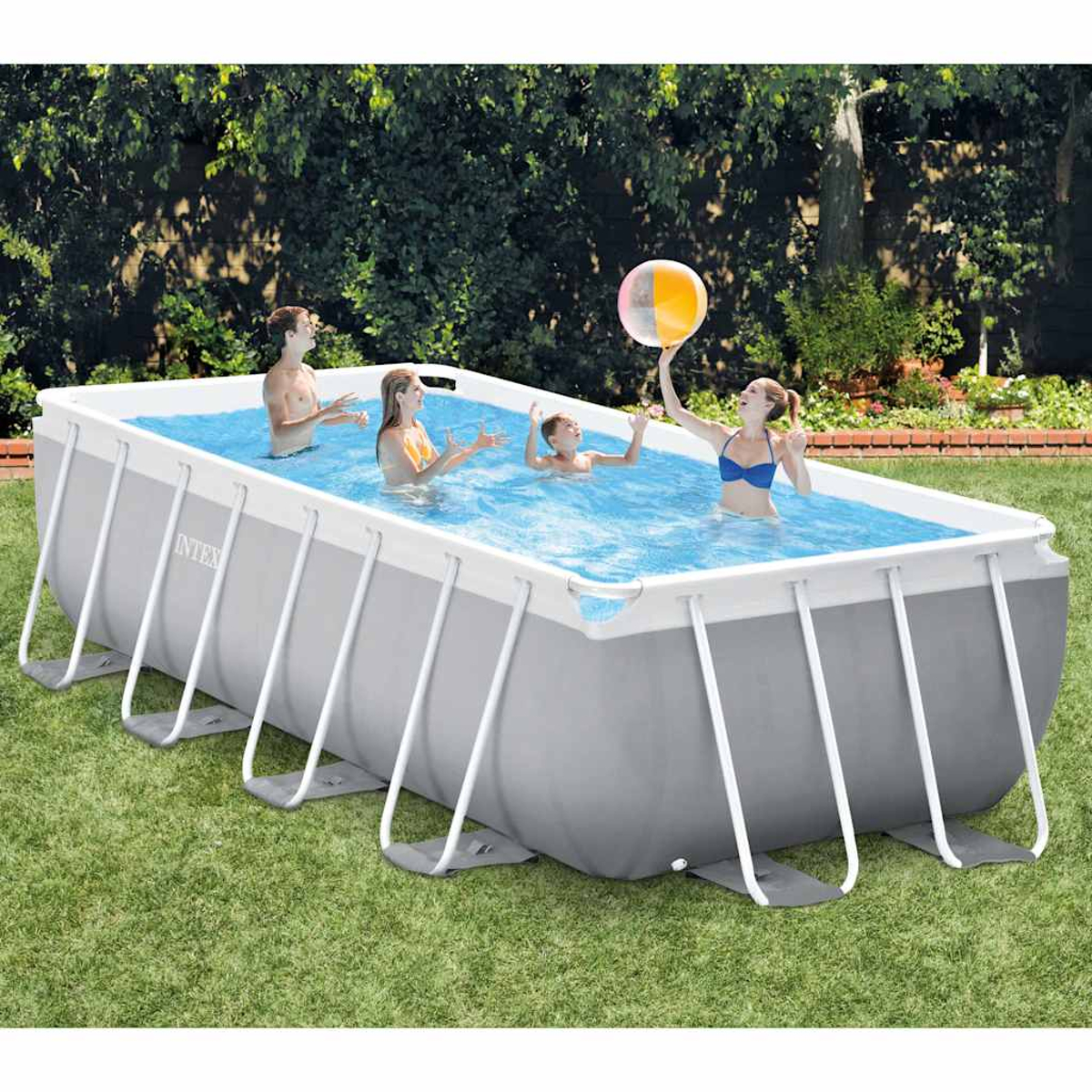 Vier Personen in einem rechteckigen Pool, eine hält einen Ball. Der Pool befindet sich in einem Garten mit Bäumen im Hintergrund und grünem Gras.