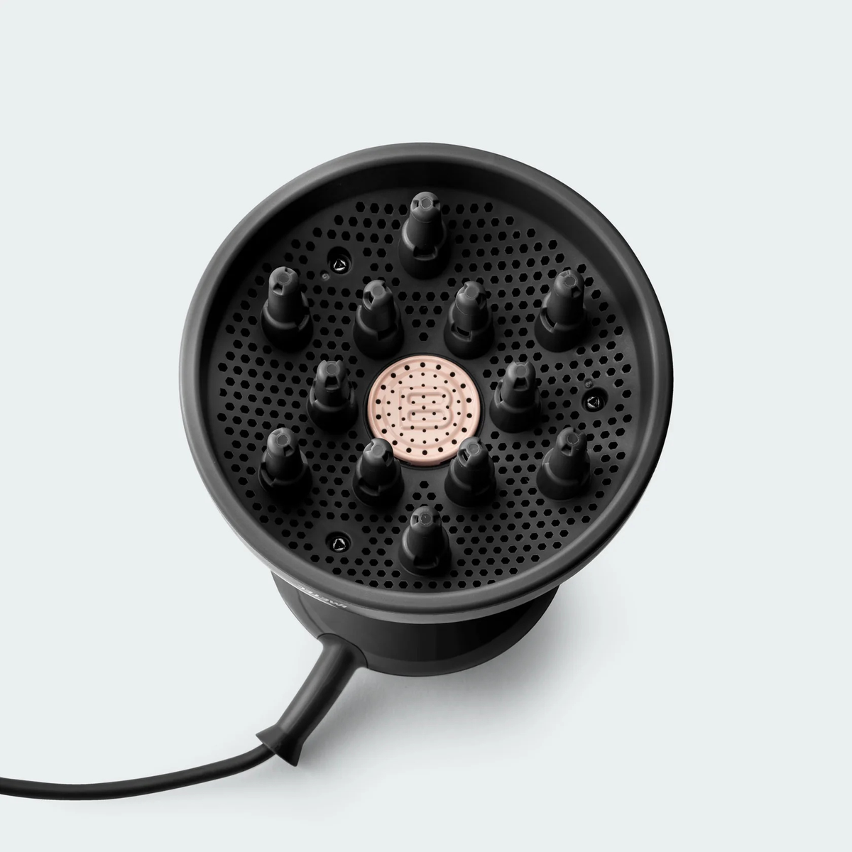 Czarny dyfuzor do suszarki do włosów ze złotym różowym środkiem na białym tle. Dyfuzor ma dysze i przewód zasilający.