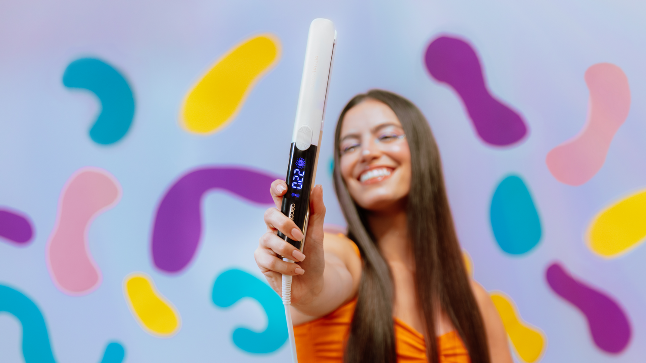 Una donna sorridente alza una piastra bianca. Lo sfondo ha forme astratte colorate.