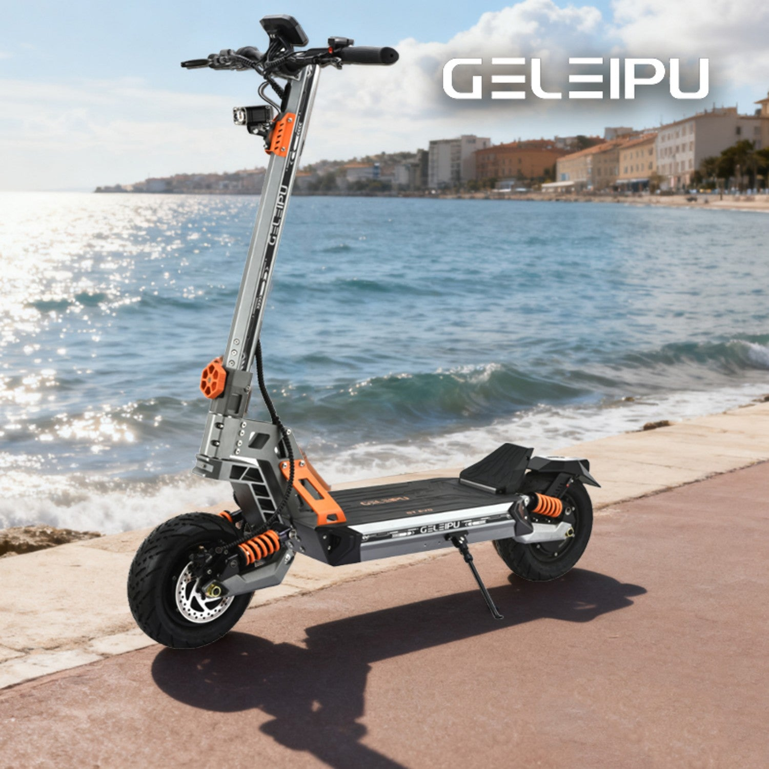 Un monopattino elettrico è parcheggiato su una passerella vicino alla spiaggia. È argento e arancione. Edifici e mare sullo sfondo.