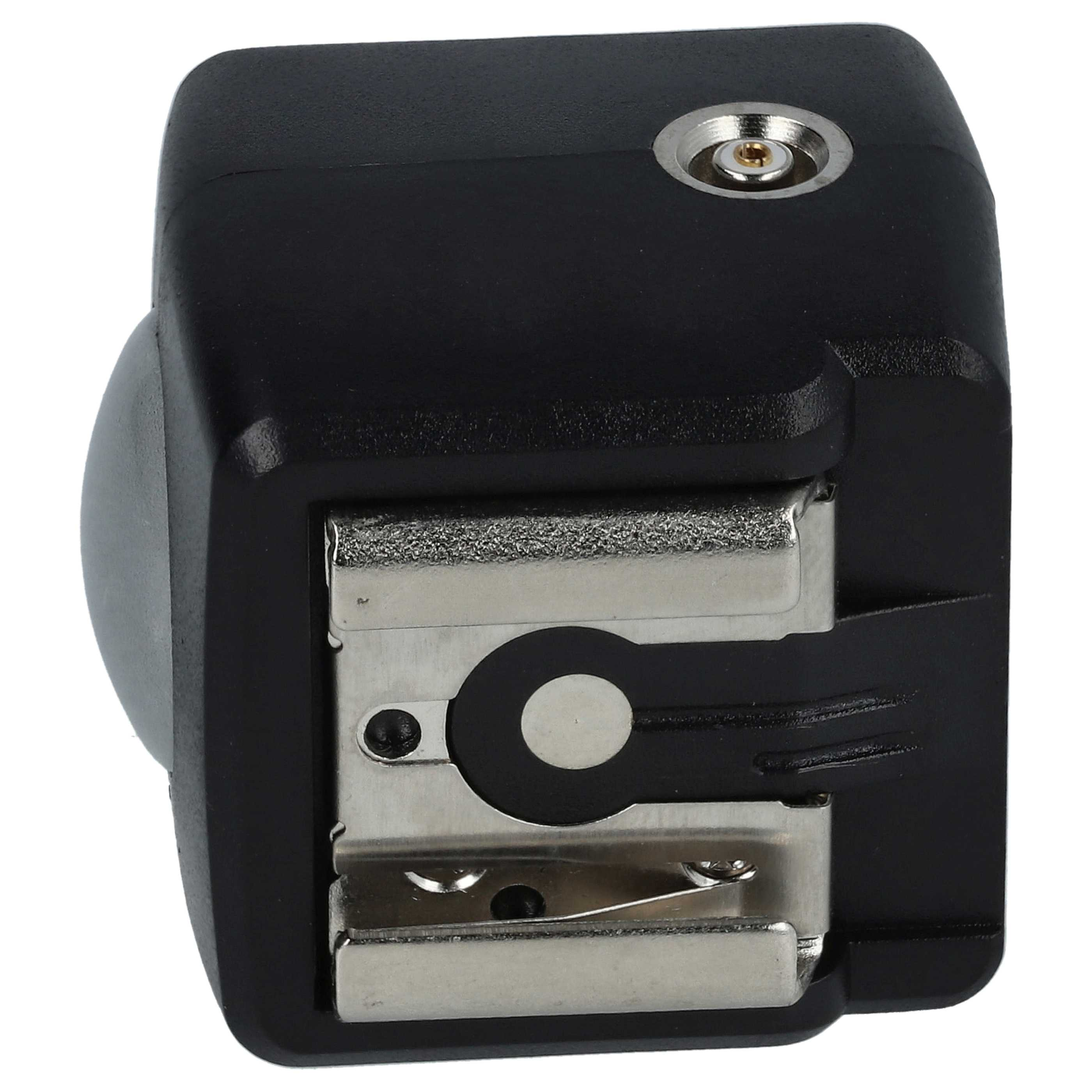 Ein schwarzer Kamera-Blitzadapter. Er hat eine silberne Blitzschuhhalterung und einen silberfarbenen Stift auf der Oberseite. Der Adapter befindet sich auf weißem Hintergrund.