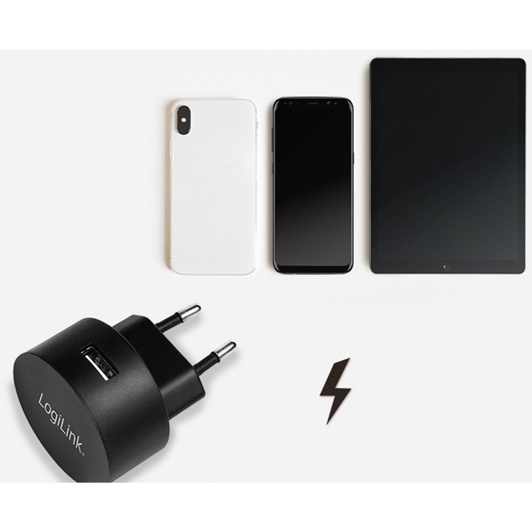 Schwarzes Ladegerät, drei Smartphones und ein Tablet auf weißem Hintergrund. Blitzsymbol.