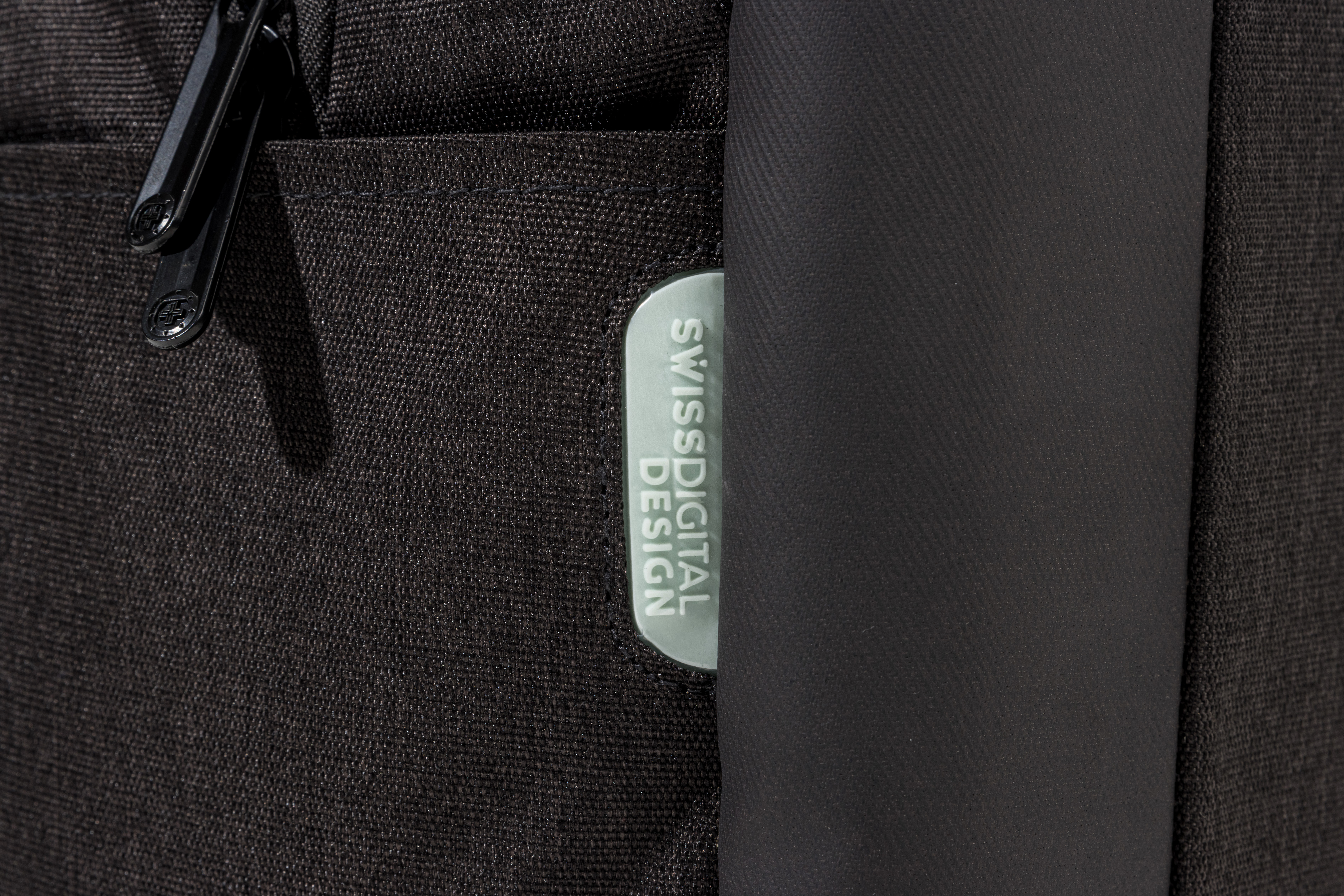 Primo piano di una borsa nera con cerniera e un'etichetta con scritto Swiss Digital Design.