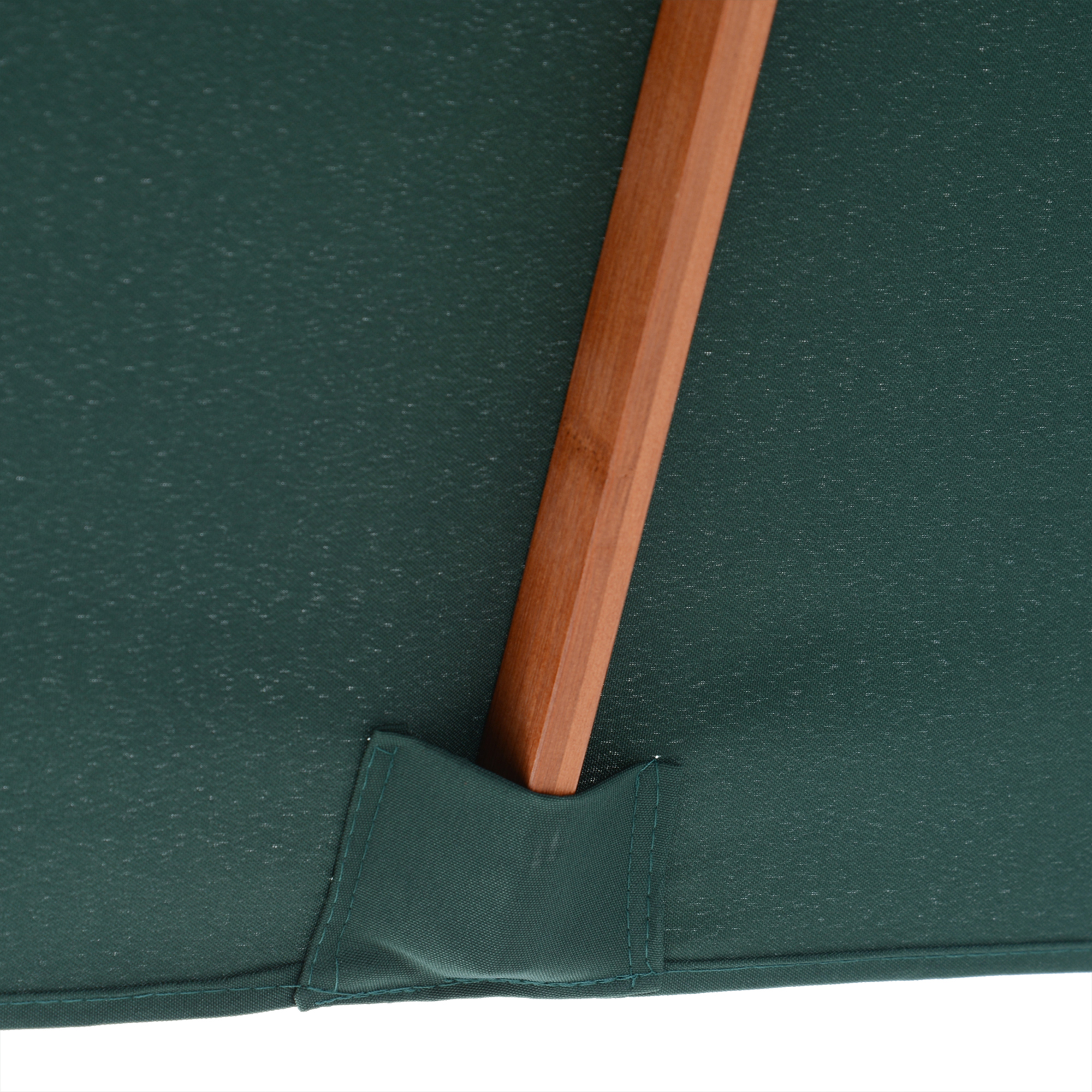 Primo piano del lato inferiore di un ombrello verde con supporto in legno. Il tessuto ha una superficie leggermente strutturata. Il supporto è angolato.