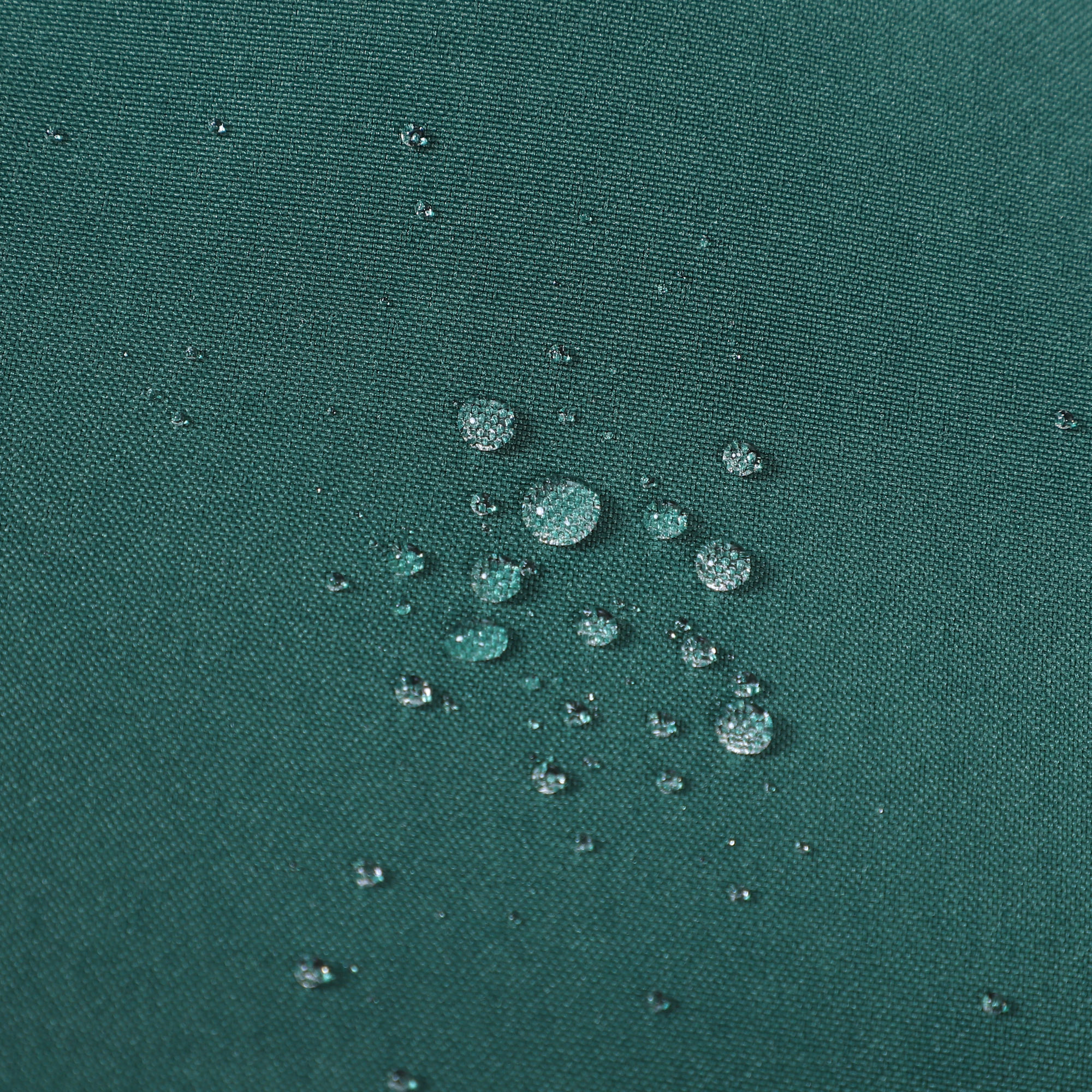 Primer plano de tela verde azulado con gotas de agua, mostrando textura y tensión superficial. La tela es ligeramente texturizada.