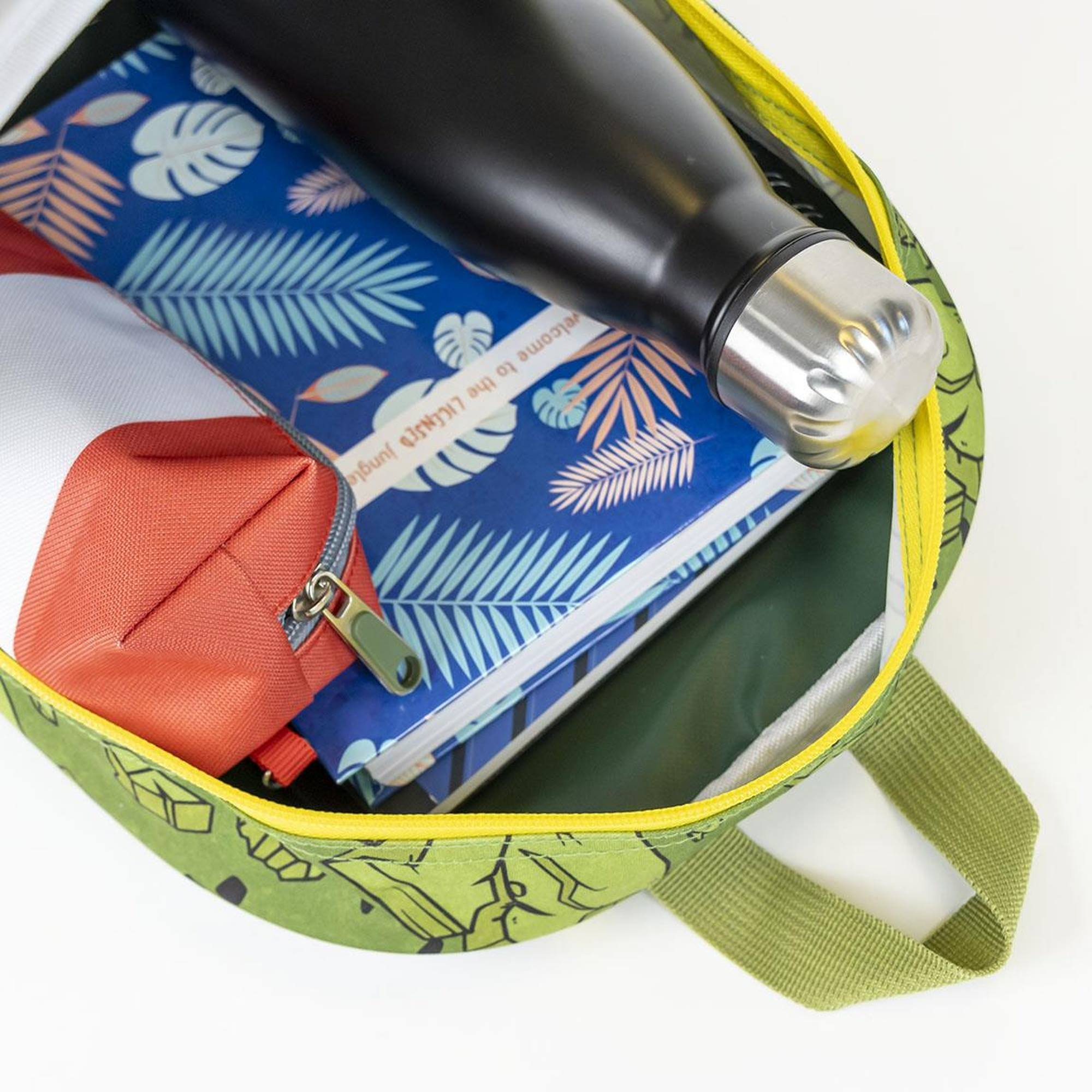 Una mochila llena de objetos: una botella de agua negra, un cuaderno con hojas, un estuche rojo y un estuche blanco.