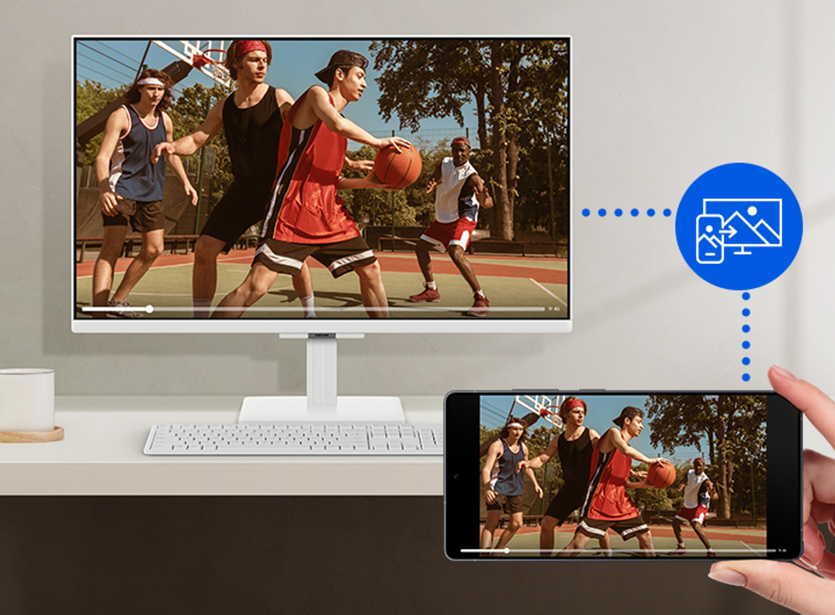 Mecz koszykówki jest przesyłany strumieniowo z monitora komputera na smartfon. Zawodnicy w czerwonych i niebieskich strojach na boisku.