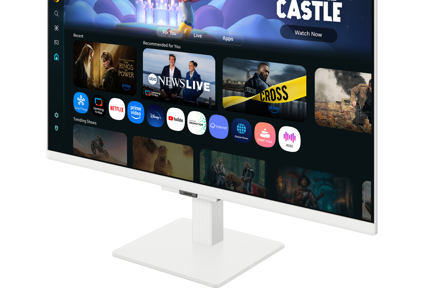 Biały monitor wyświetlający interfejs TV. Pokazuje ikony filmów i aplikacji. Monitor stoi na białej podstawie. Tło jest gładkie.