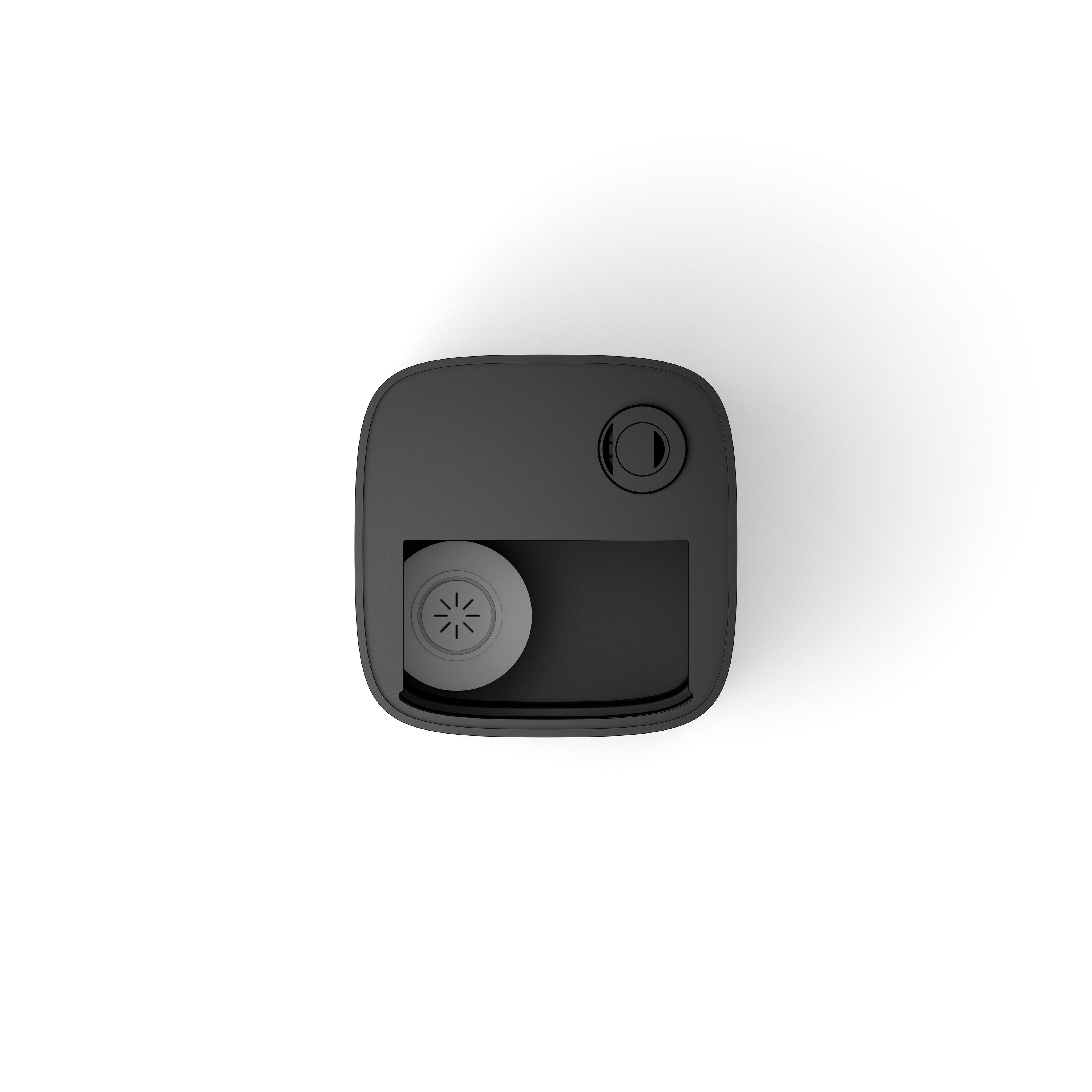 Top view of a black device with a round button and a recessed area with a circular speaker.