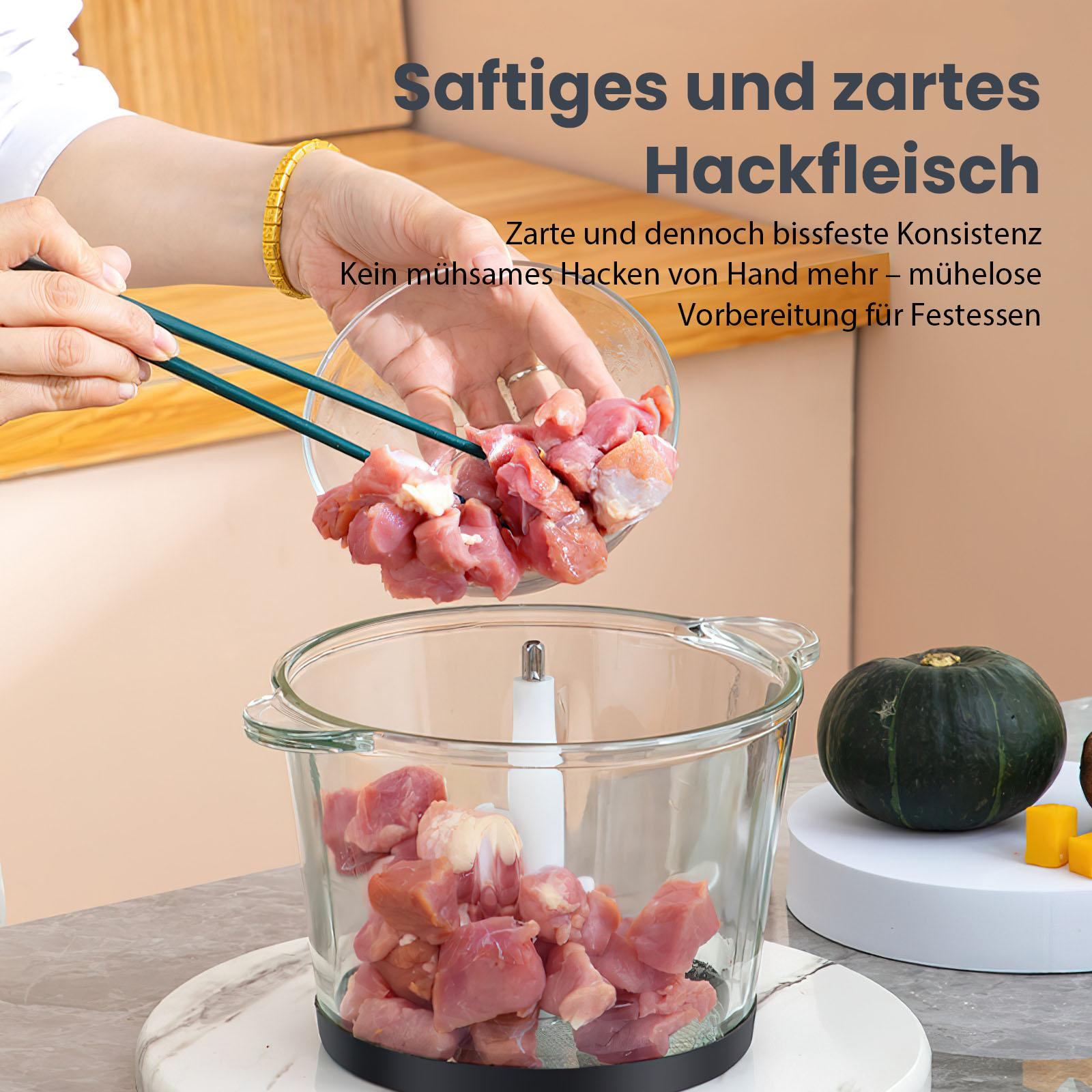 Eine Person gießt Fleisch in einen Glas-Foodprozessor. Im Hintergrund befinden sich ein Kürbis und gelbe Würfel.
