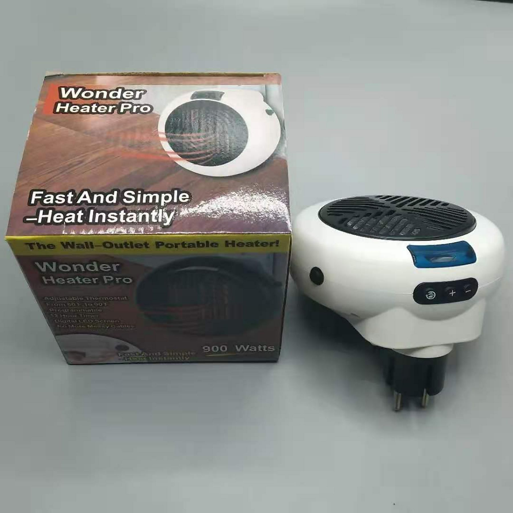 Ein weißer Wonder Heater Pro und seine Schachtel stehen auf einer weißen Oberfläche. Der Heizlüfter hat einen schwarzen Grill.