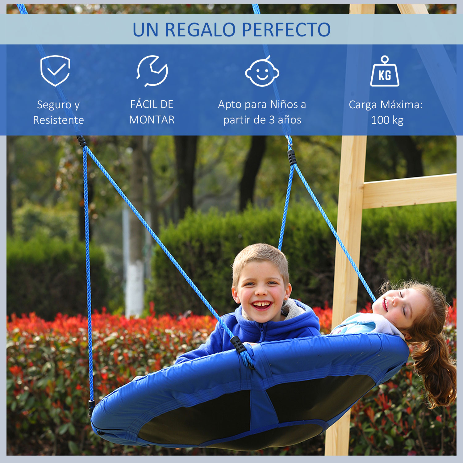 Dos niños en un columpio azul, sonriendo. El columpio cuelga de un marco de madera. Arbustos rojos en el fondo.