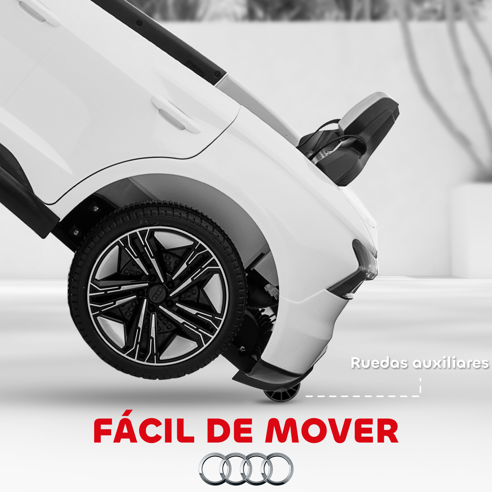Coche de juguete blanco con ruedas negras. Texto: 'Fácil de mover' y 'Ruedas auxiliares'. Logotipo de Audi abajo.