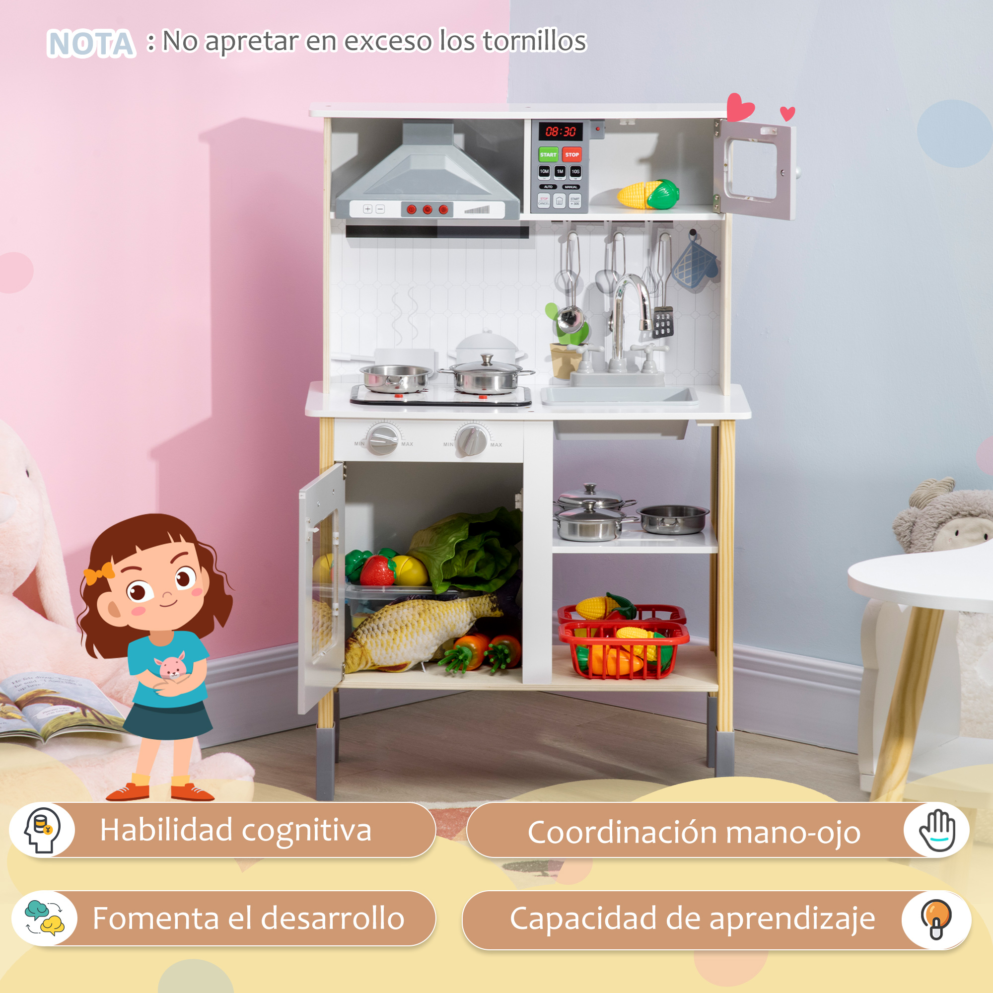Una cocina de juguete para niños con electrodomésticos y comida. Una niña está de pie enfrente. La cocina es blanca, con fondos rosas y azules.