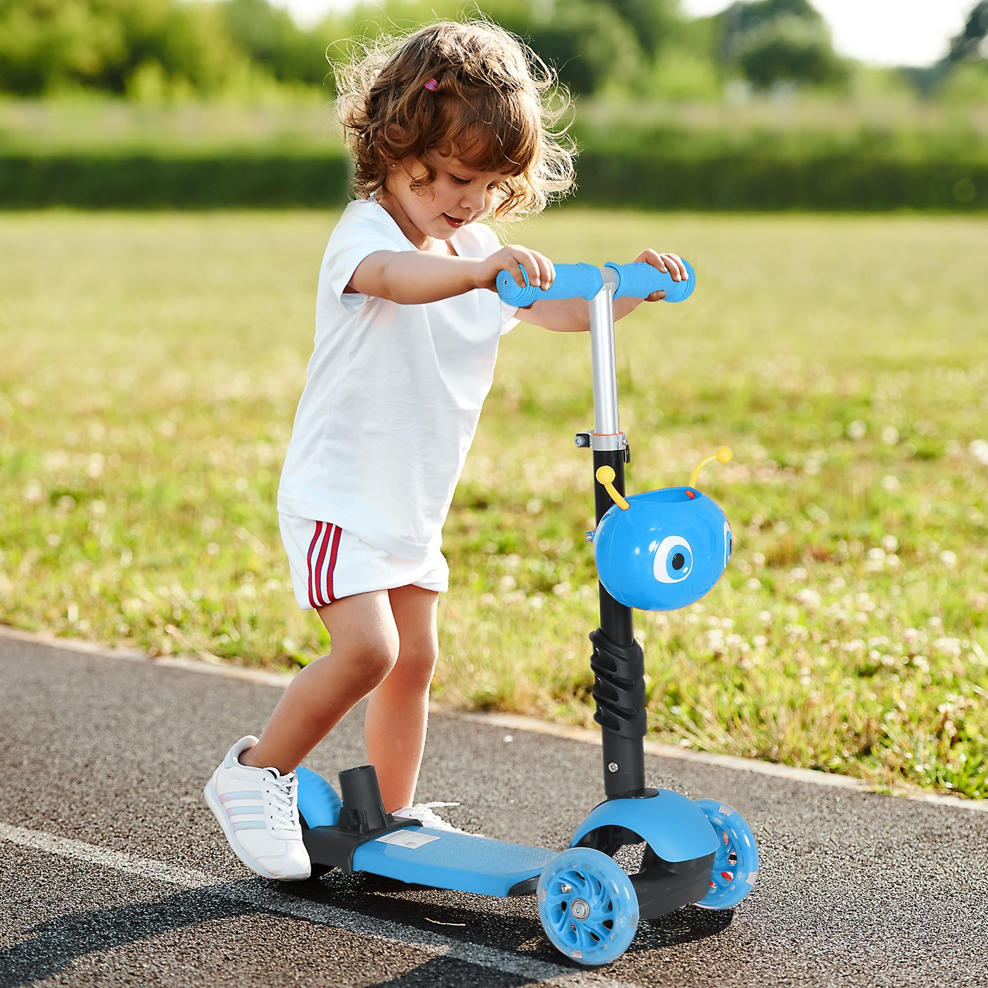 Un niño anda en un scooter azul en una pista. El niño lleva pantalones cortos y una camisa blancos. Hay hierba verde al fondo.
