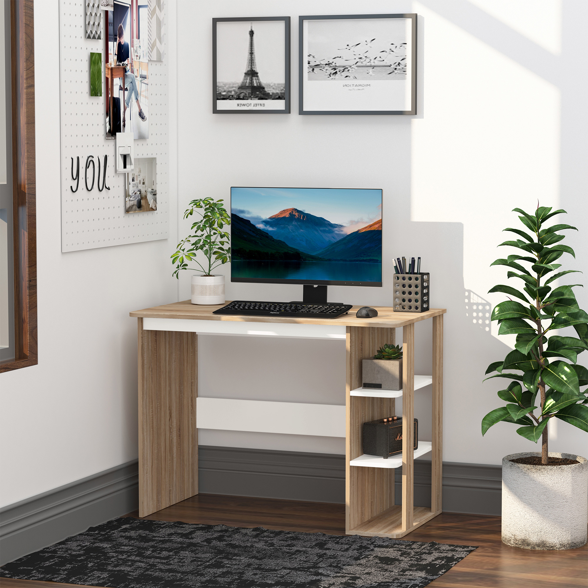 Un escritorio con computadora, plantas y objetos decorativos. Una pared con cuadros en el fondo.