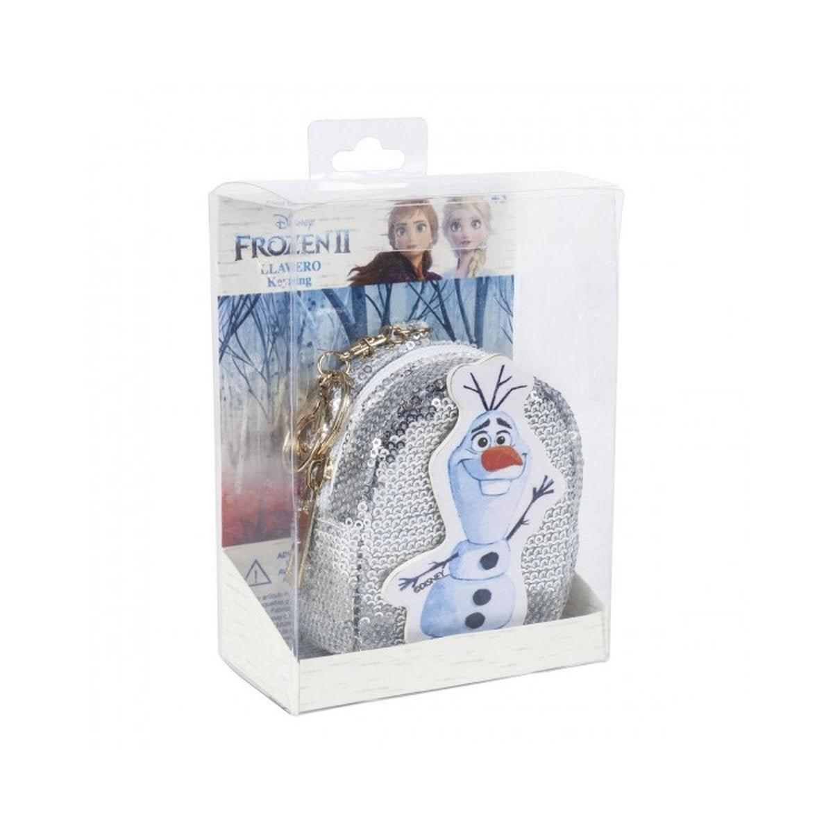 Un llavero de Frozen II en una caja de plástico transparente. El llavero es una mochila plateada con lentejuelas y un personaje de Olaf. La caja tiene un fondo de Frozen II.