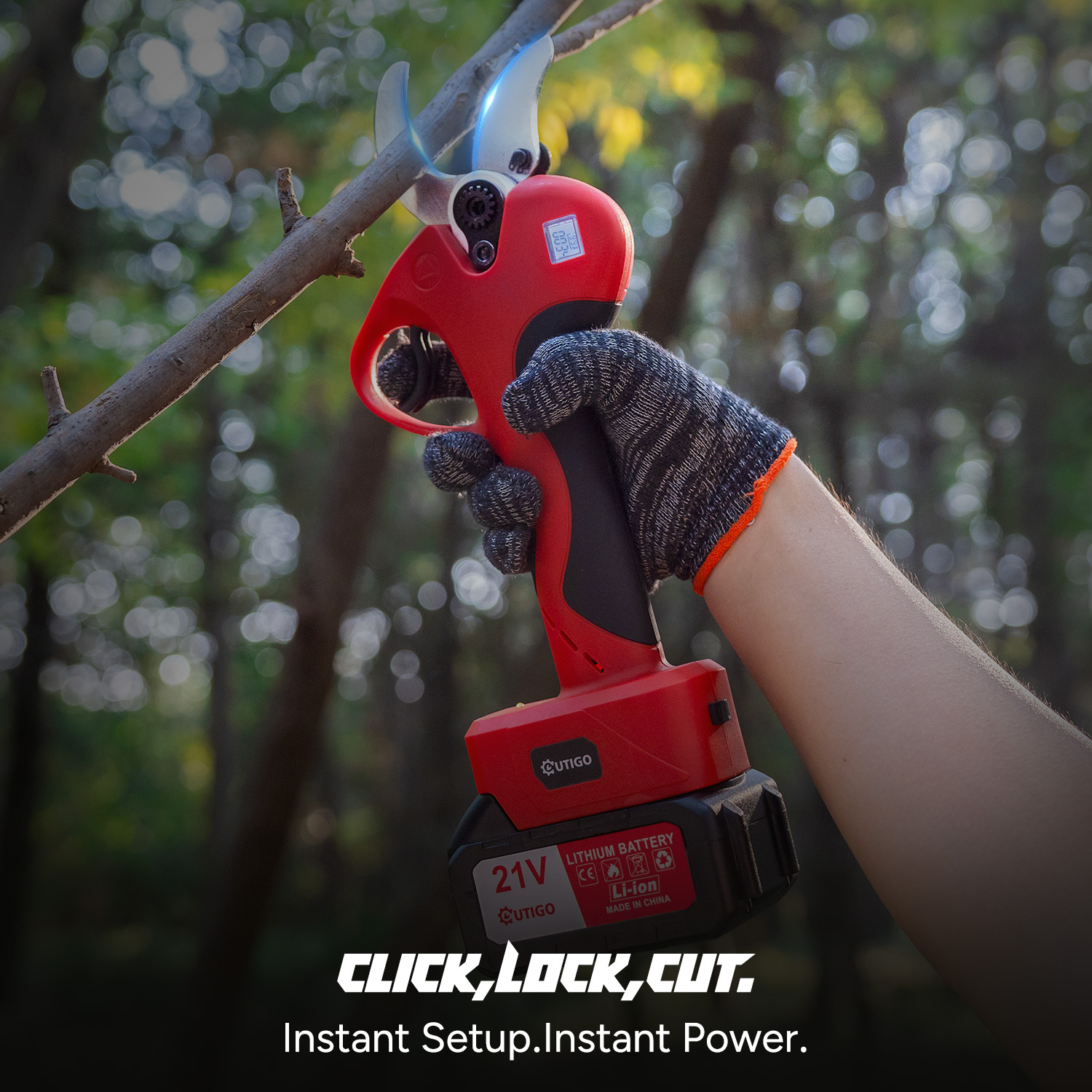 Ręka trzymająca czerwono-czarne elektryczne nożyce do przycinania, tnące gałąź drzewa. Tekst: CLICK,LOCK,CUT. Instant Setup.Instant Power.