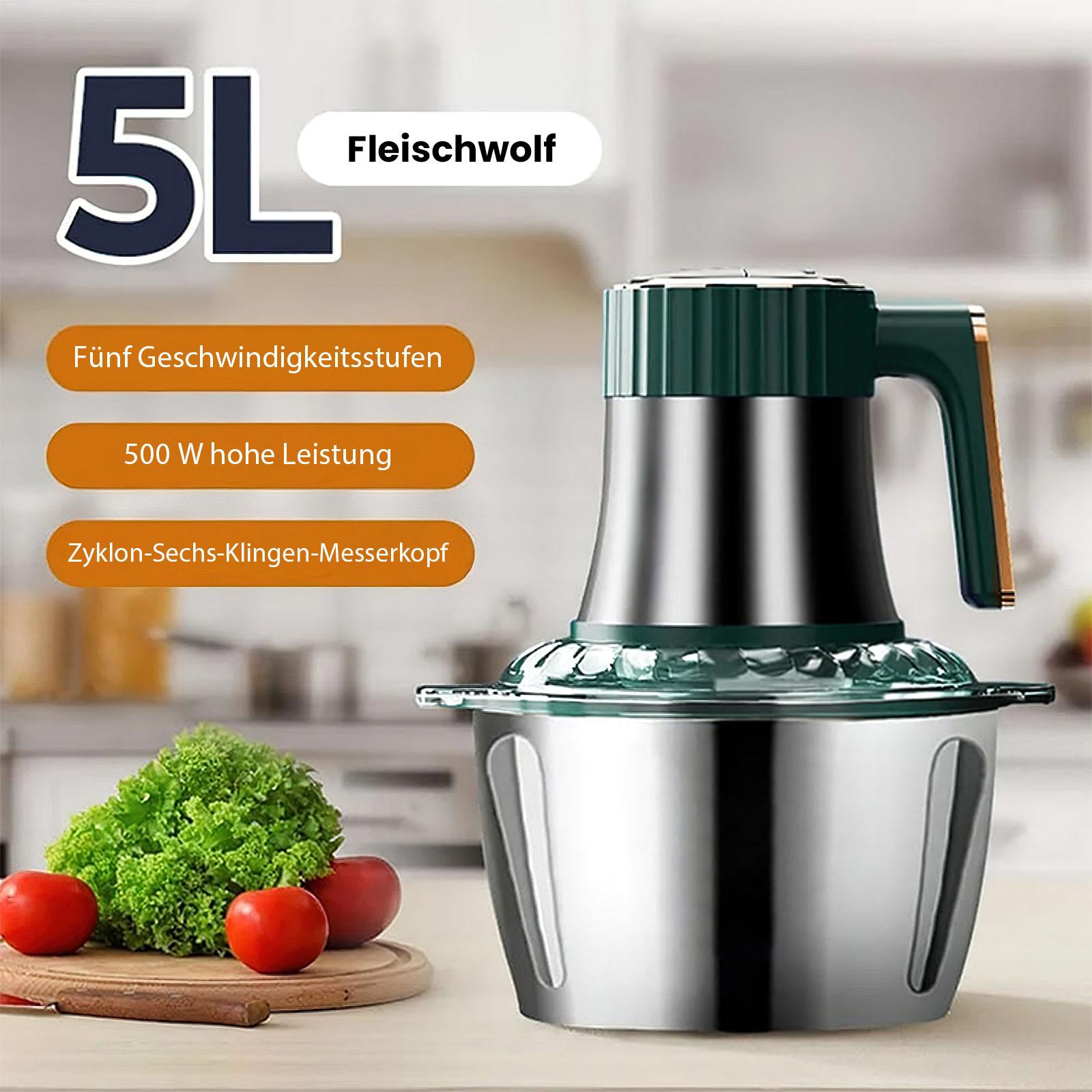 Ein Küchengerät mit grünem Deckel und Griff, Edelstahlschüssel und Gemüse auf einem Holzschneidebrett.