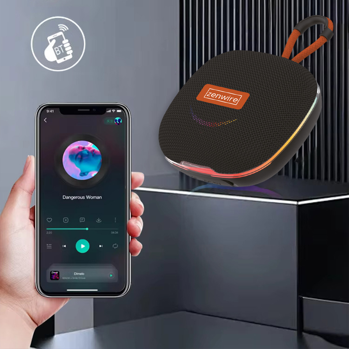 Ręka trzymająca telefon z muzyką, czarny głośnik z pomarańczowym uchwytem i ikoną Bluetooth.