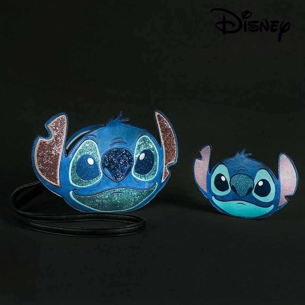 Dos bolsas con forma de Stitch, azules con detalles brillantes, sobre una superficie negra. La más grande tiene una correa. Logotipo de Disney arriba.