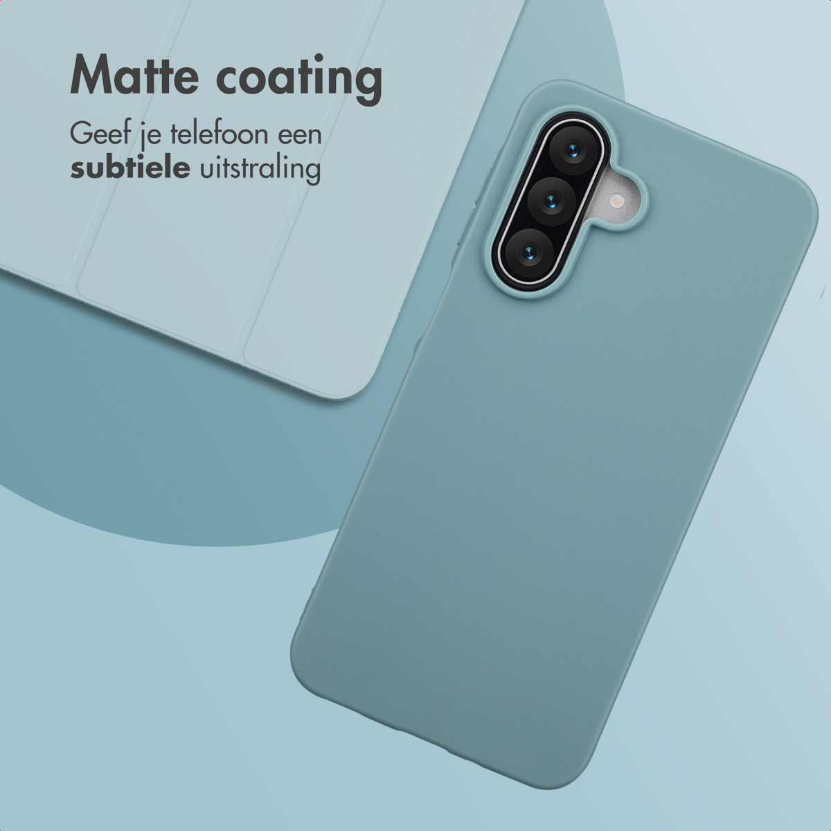 Een blauwgroene telefoonhoes met een drievoudige cameralens staat schuin op een blauw oppervlak met een witte laptopcover.