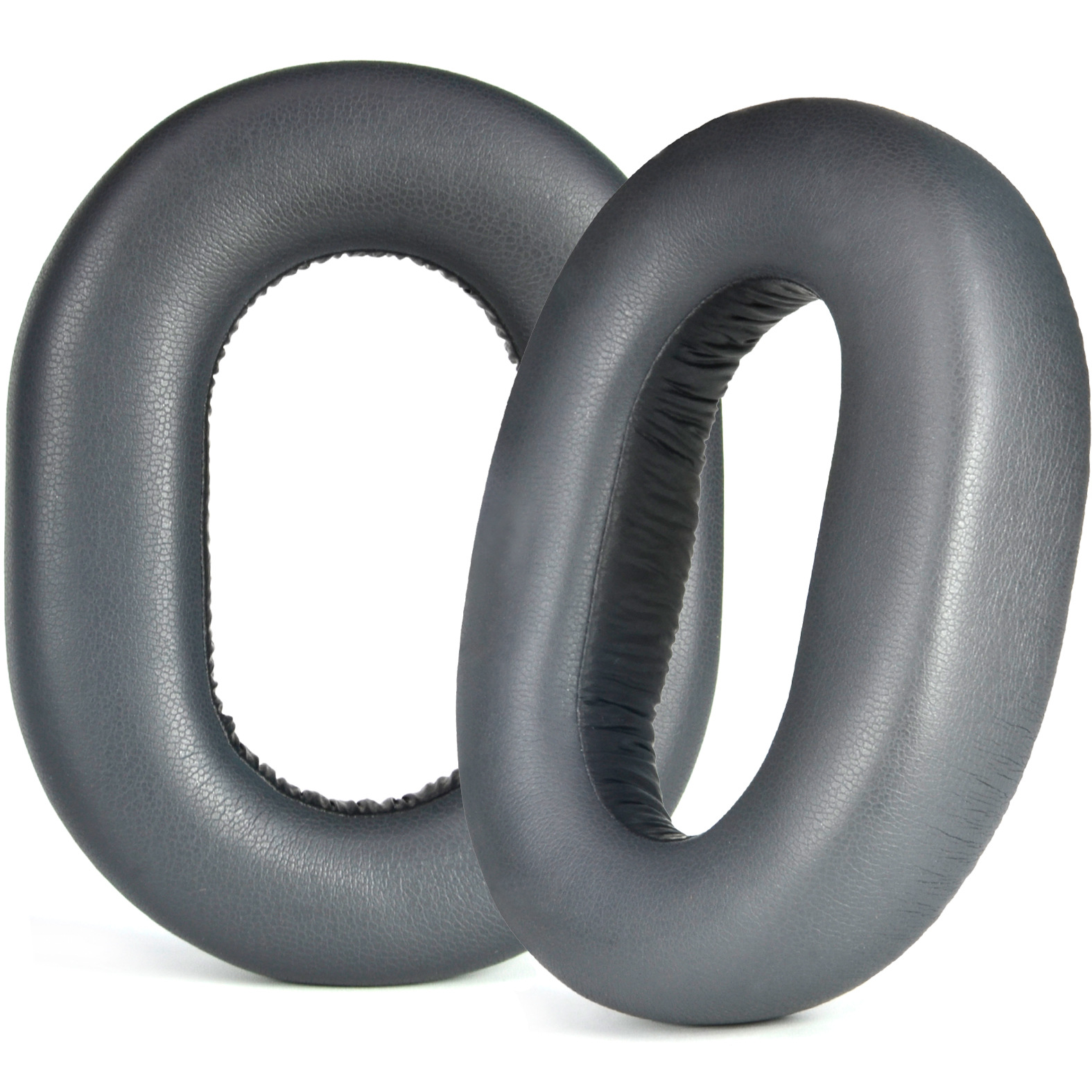 Dwie szare, owalne poduszki nauszne do słuchawek. Wykonane są z teksturowanego materiału, na białym tle.