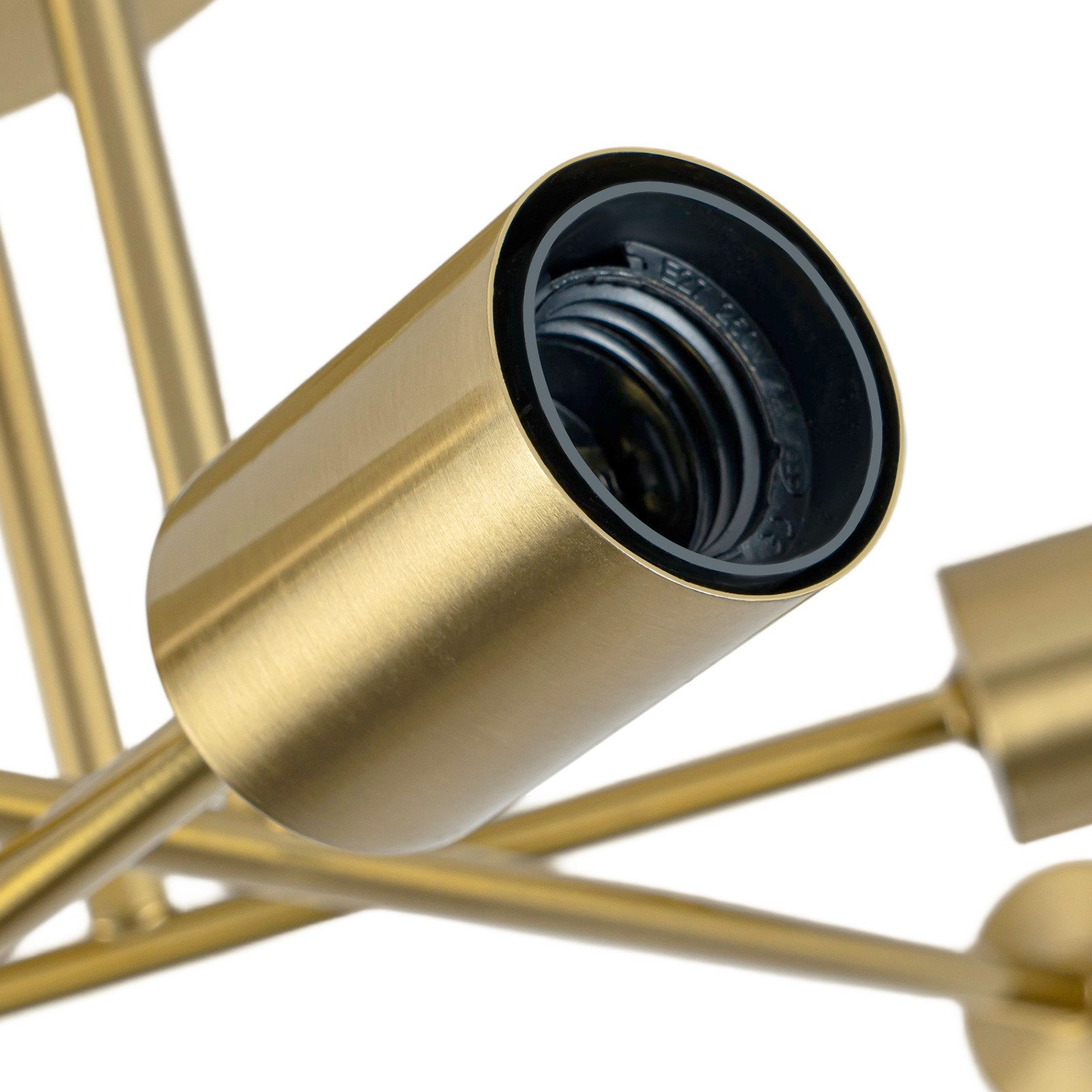 Zbliżenie złotego oświetlenia. Ostrość skupia się na gnieździe żarówki. Tło jest białe.