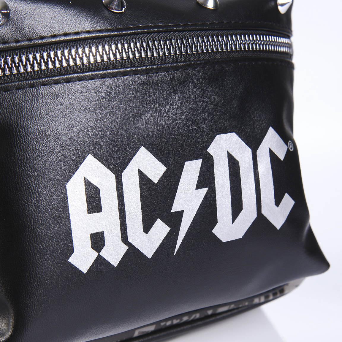 Bolso negro con el logo AC/DC en blanco. Cremallera y tachuelas plateadas. Textura de cuero. Fondo blanco.