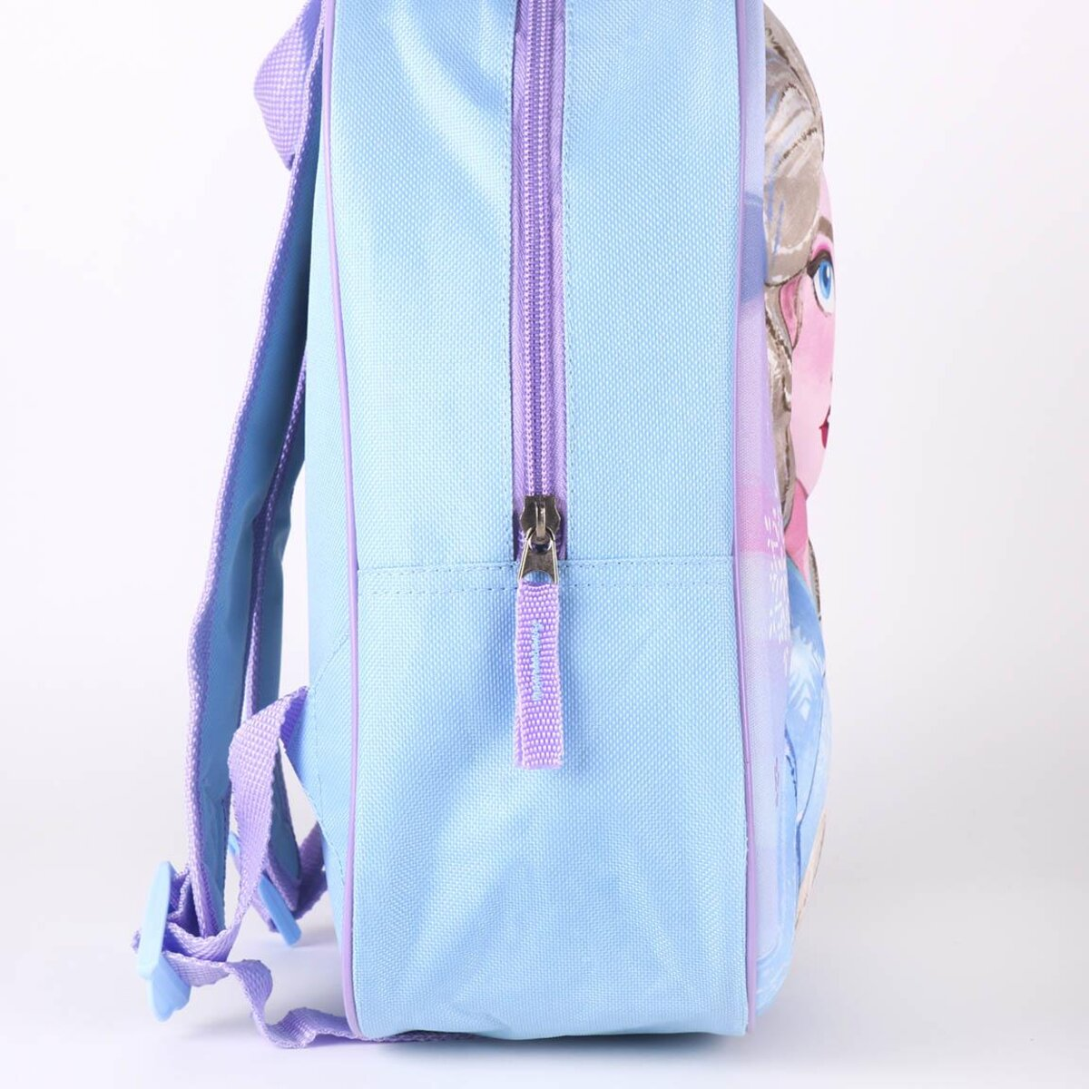 Una mochila azul claro con ribetes y correas moradas. Tiene una cremallera y una imagen de un personaje de dibujos animados en el lateral.