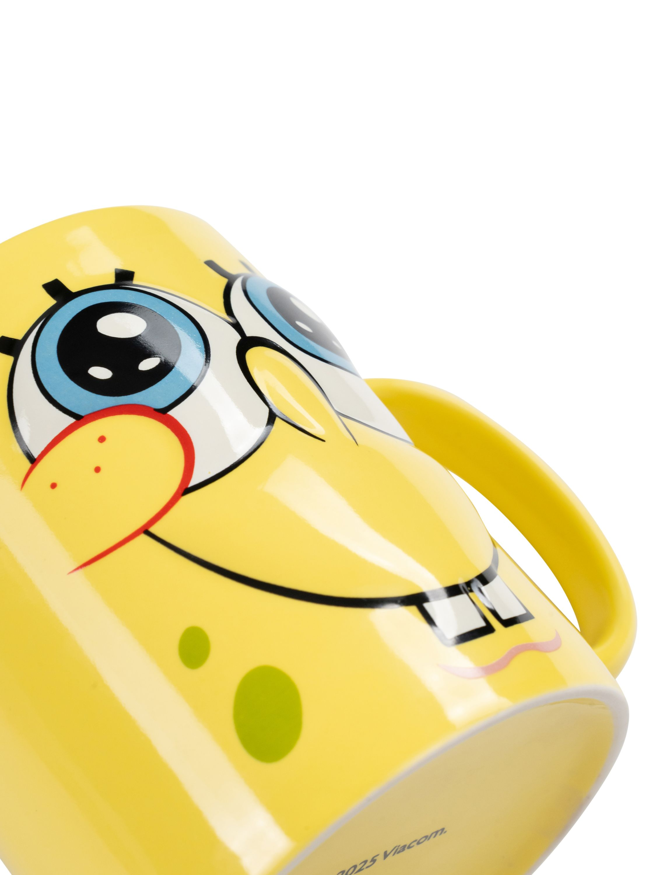 Eine gelbe SpongeBob-Tasse ist geneigt. Sie hat SpongeBobs Gesicht, mit blauen Augen und einem roten Lächeln.