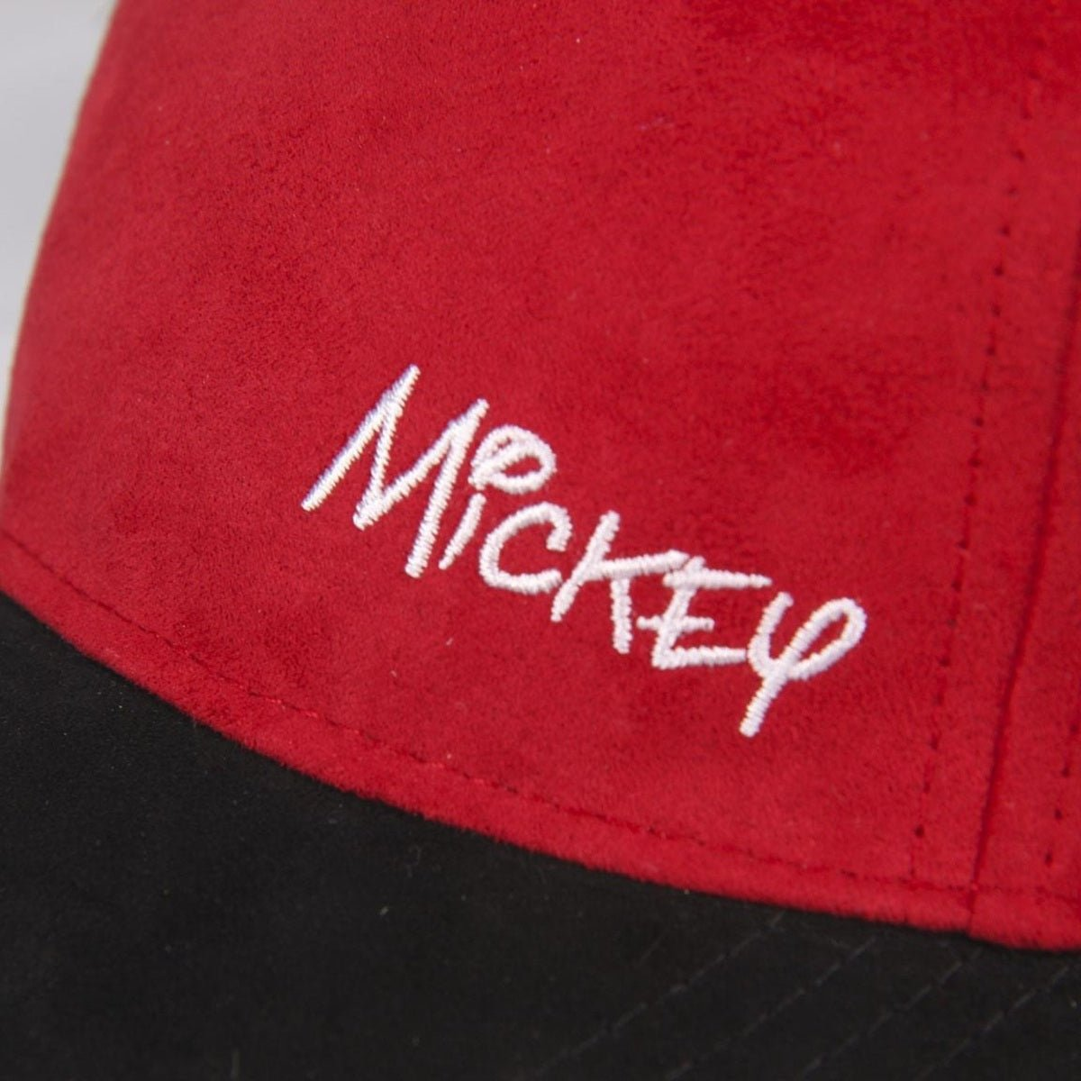 Una gorra de béisbol roja con la palabra 'Mickey' bordada en blanco. La parte inferior es negra.