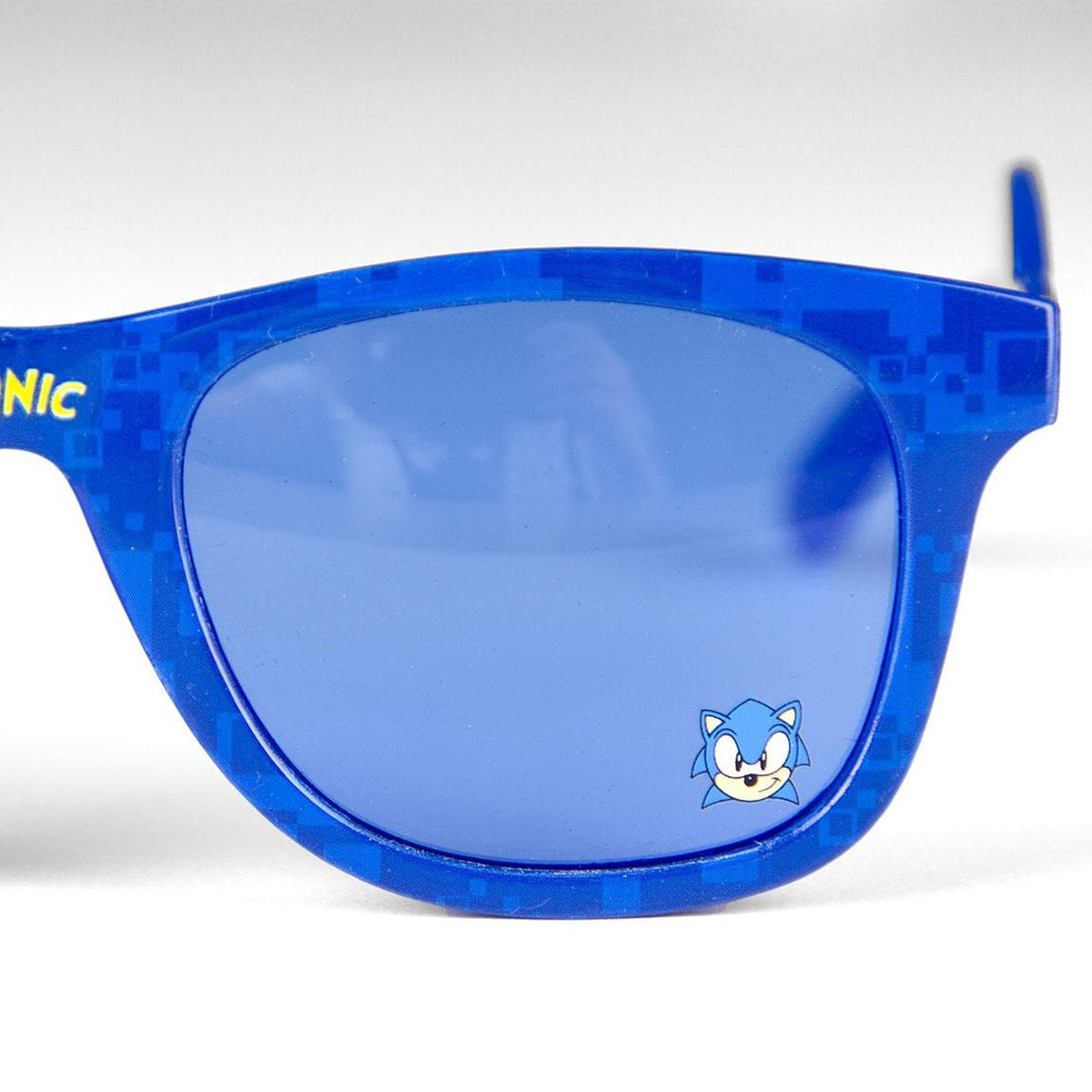 Gafas de sol azules con el logo de Sonic the Hedgehog en la lente. La montura es azul con diseño pixelado.